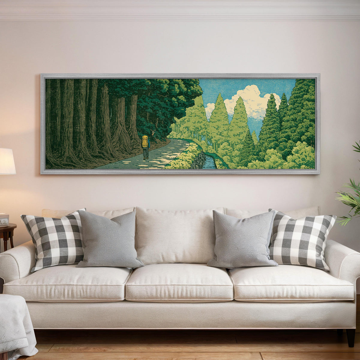 Hiker on a forest trail panoramic canvas print above a white sofa in a bright living room