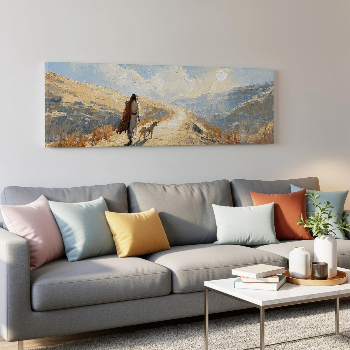 Jesus walking a sunlit hillside path with a sheep panoramic canvas print above a grey sofa in a living room