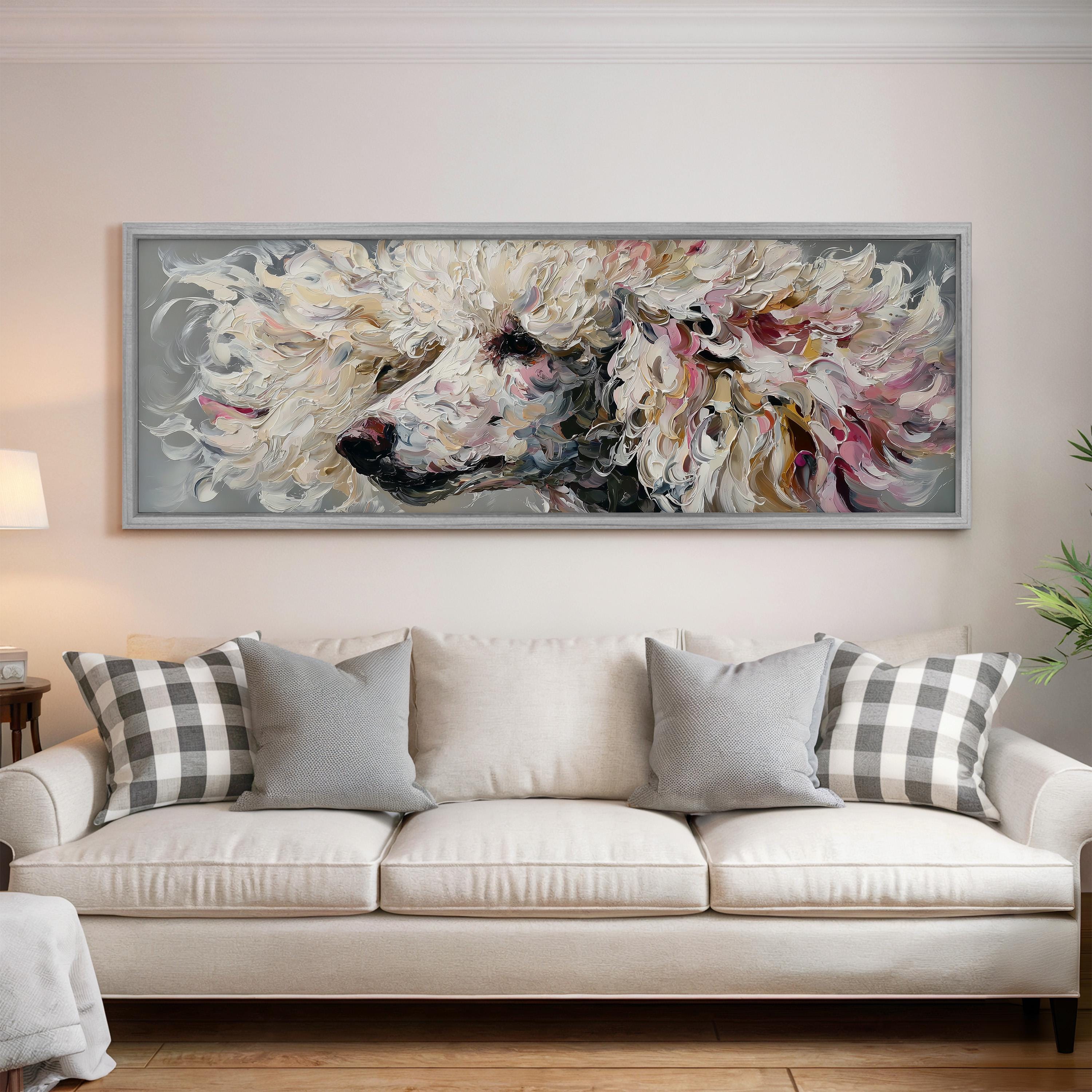 a large, colorful painting of a poodle's face hanging on a wall above a white couch with gray and white plaid throw pillows.