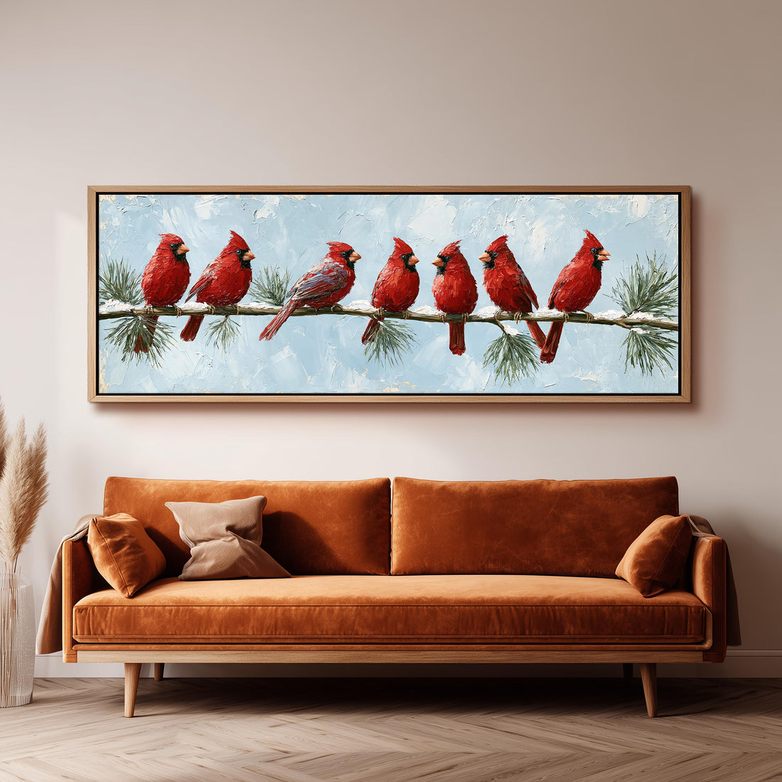 Red cardinals on a snowy pine branch long horizontal canvas print above a sofa in a living room