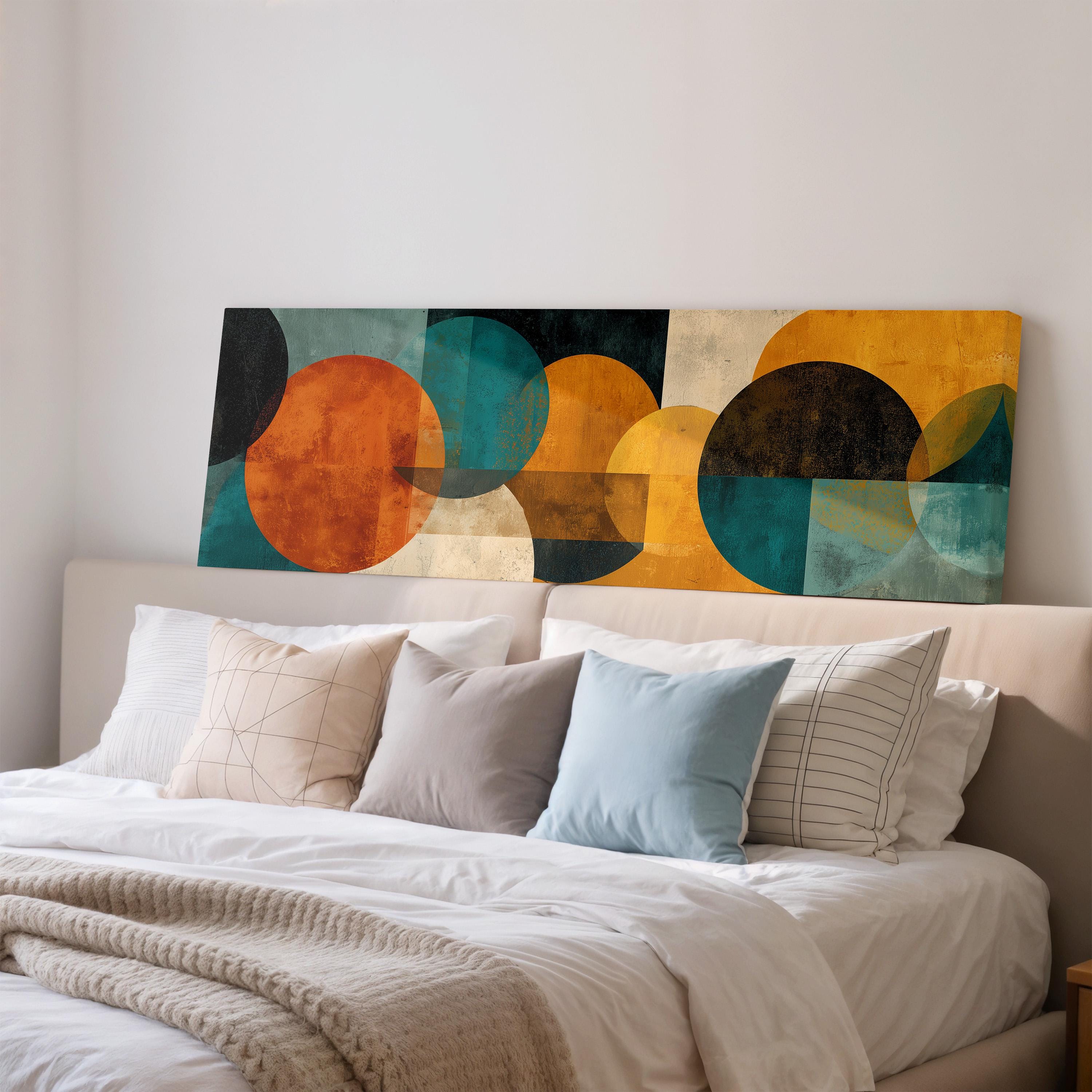 a modern bedroom with a large abstract painting on the wall above a bed with white pillows and a gray blanket.