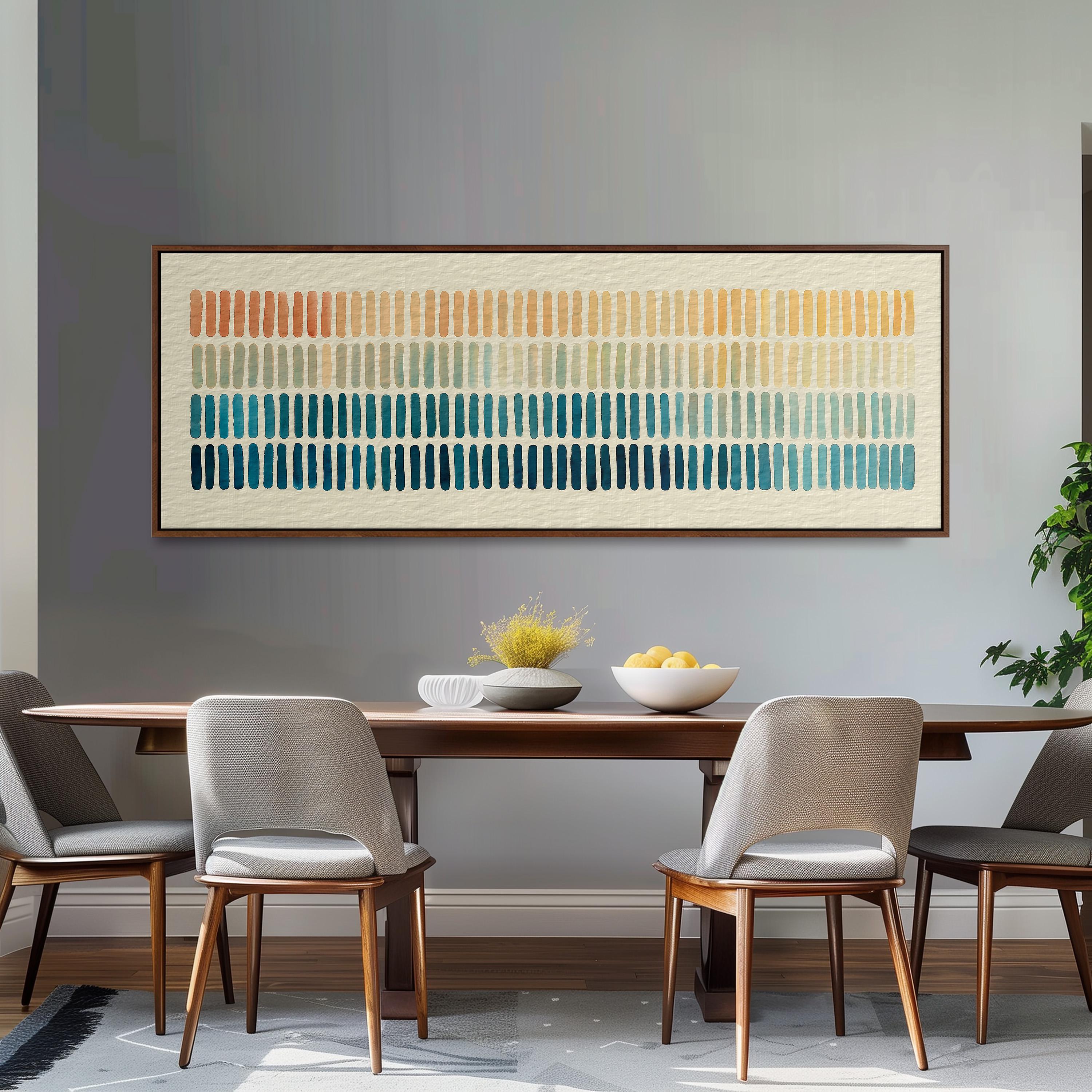 a dining room with a wooden table and four gray chairs. Above the table, there is a large abstract painting with horizontal lines in various colors. On the table, there is a bowl of fruit and a vase of flowers.
