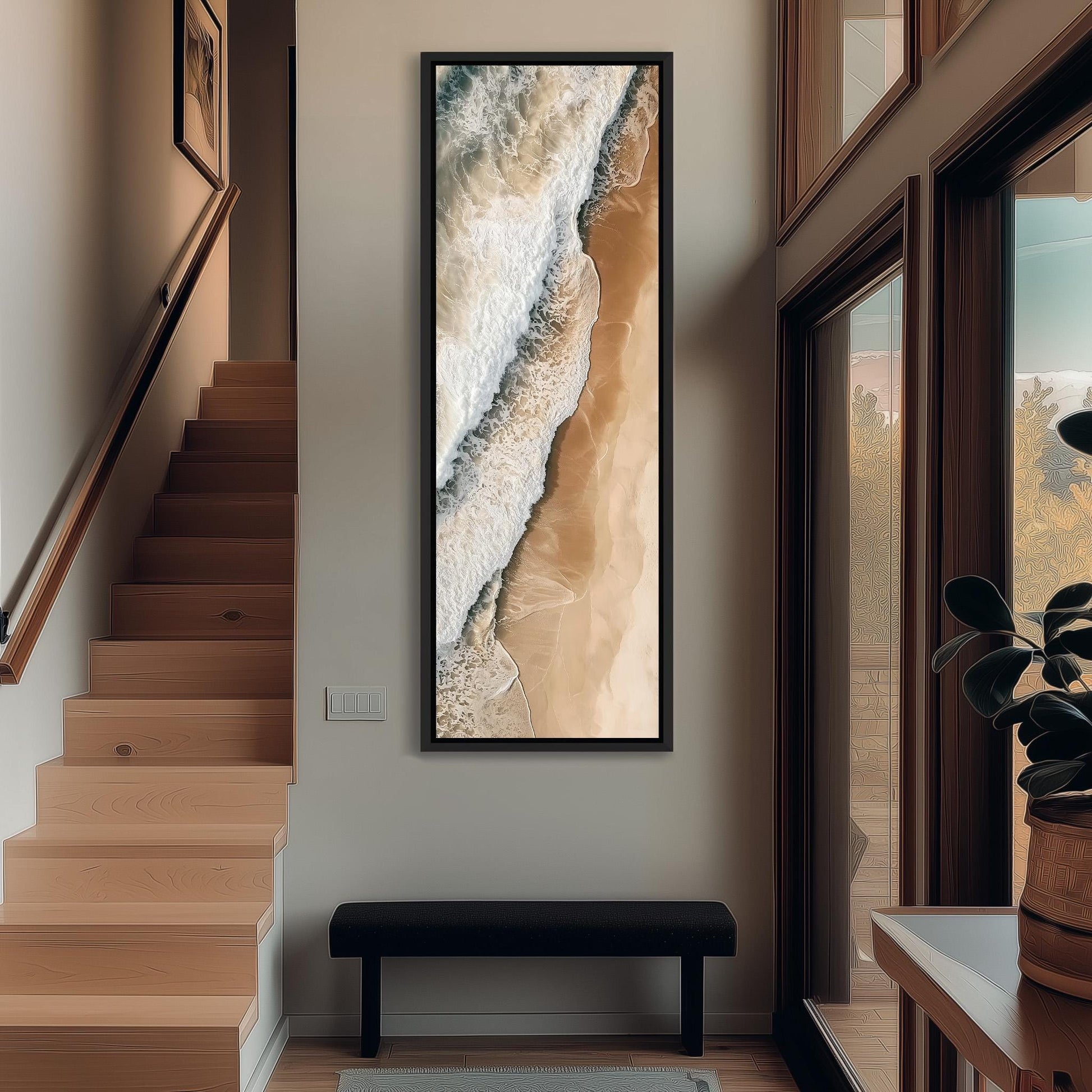 a hallway with a large painting of a beach scene hanging on the wall. The painting depicts a beach with waves crashing against the shore, creating a serene and calming atmosphere. The hallway is well-lit, with a staircase leading up to the painting, and a bench placed in front of it. The overall design of the hallway is modern and minimalist, with a focus on natural elements and a sense of tranquility.