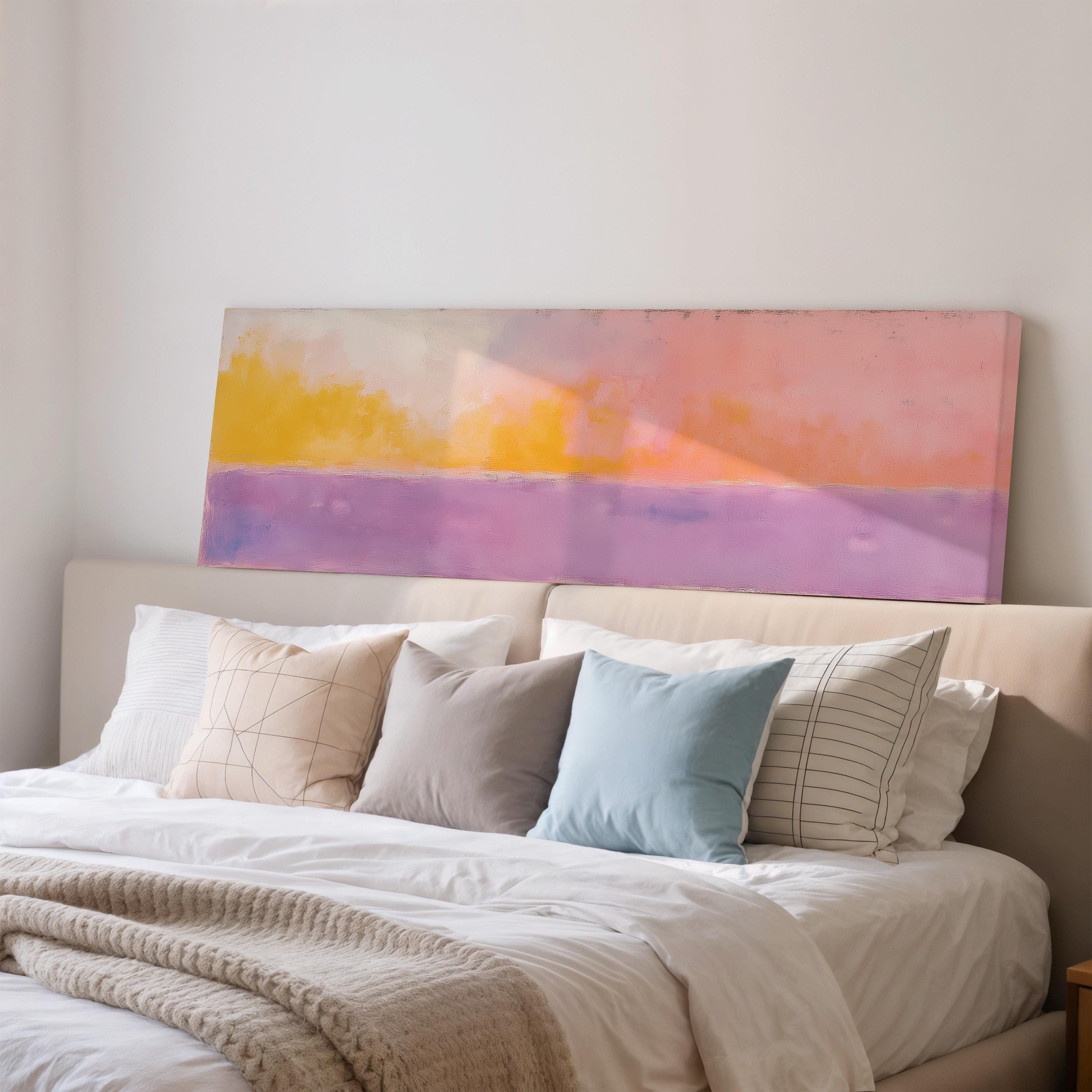 a cozy bedroom with a large bed adorned with white linens and a variety of colorful pillows. Above the bed, there is a large painting or artwork featuring a vibrant color palette of pink, orange, and purple.