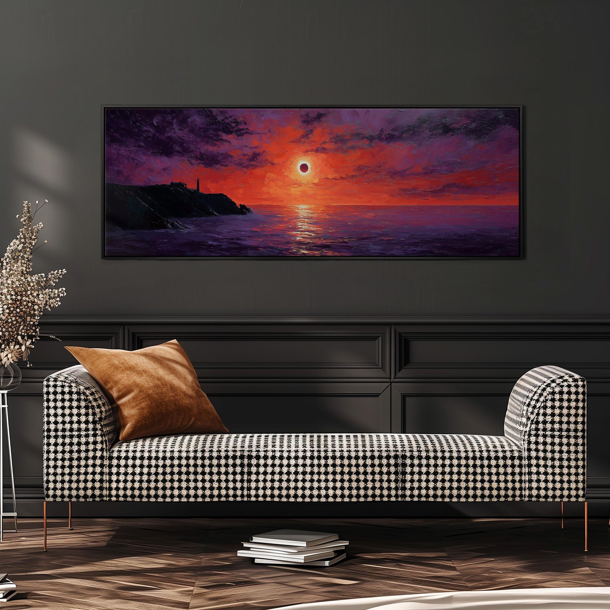 a large, framed painting of a sunset over the ocean, hanging on a wall above a black and white checkered sofa.