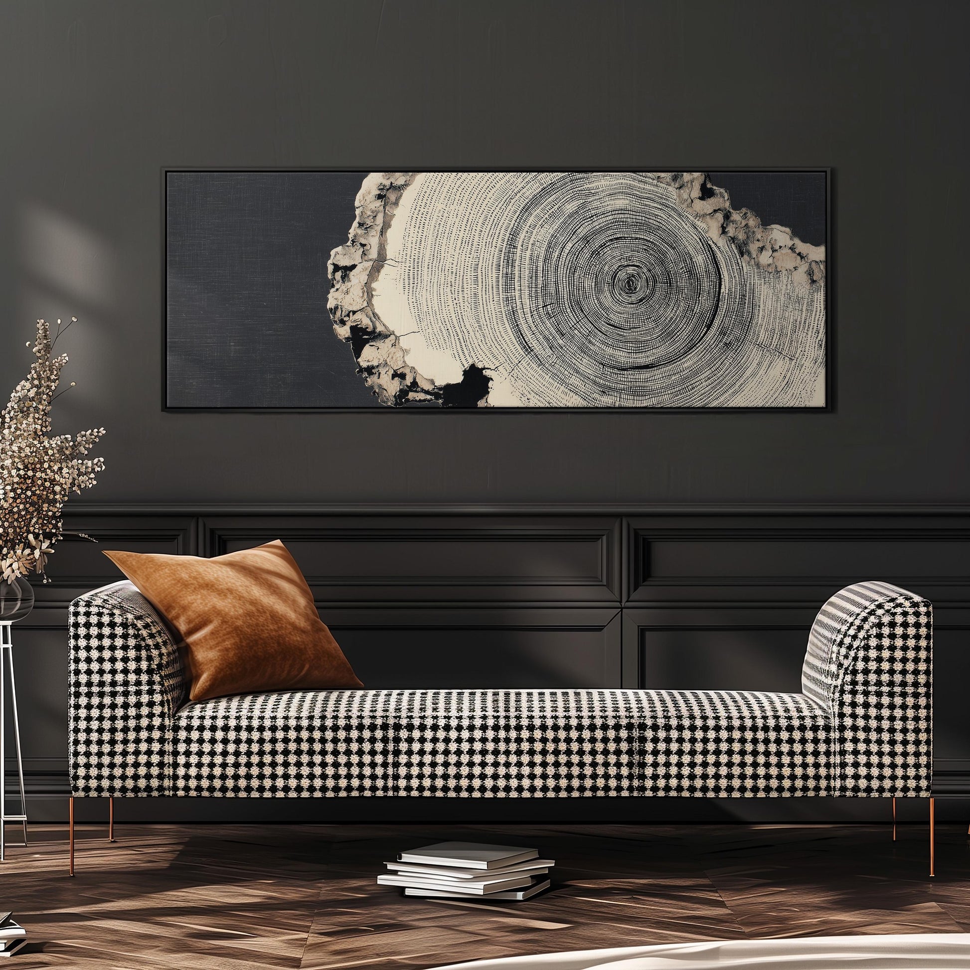a black and white checkered sofa with a brown throw pillow, set against a dark wall with a large framed artwork hanging above it.