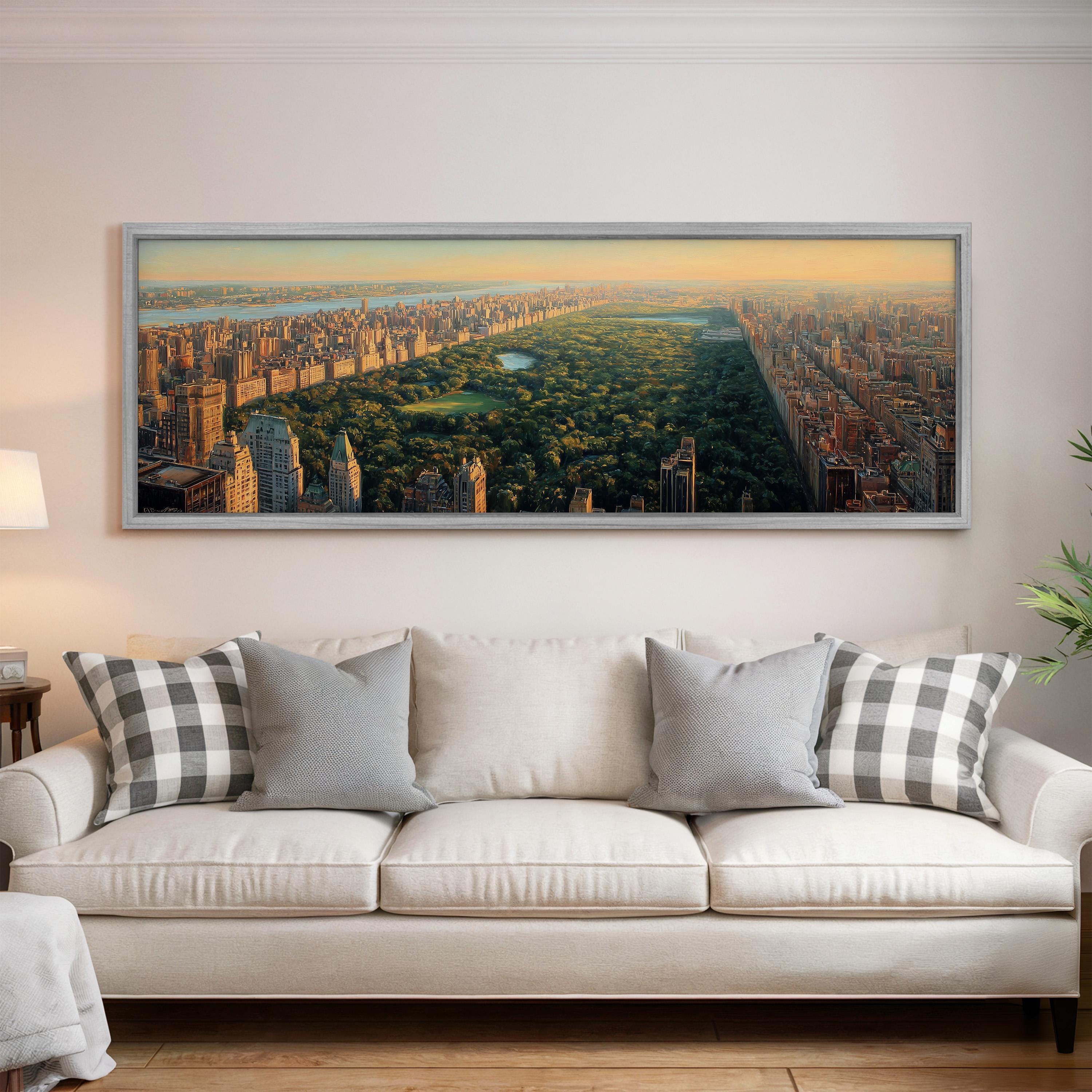 A large framed picture of a cityscape hangs on a wall above a white sofa with patterned throw pillows.