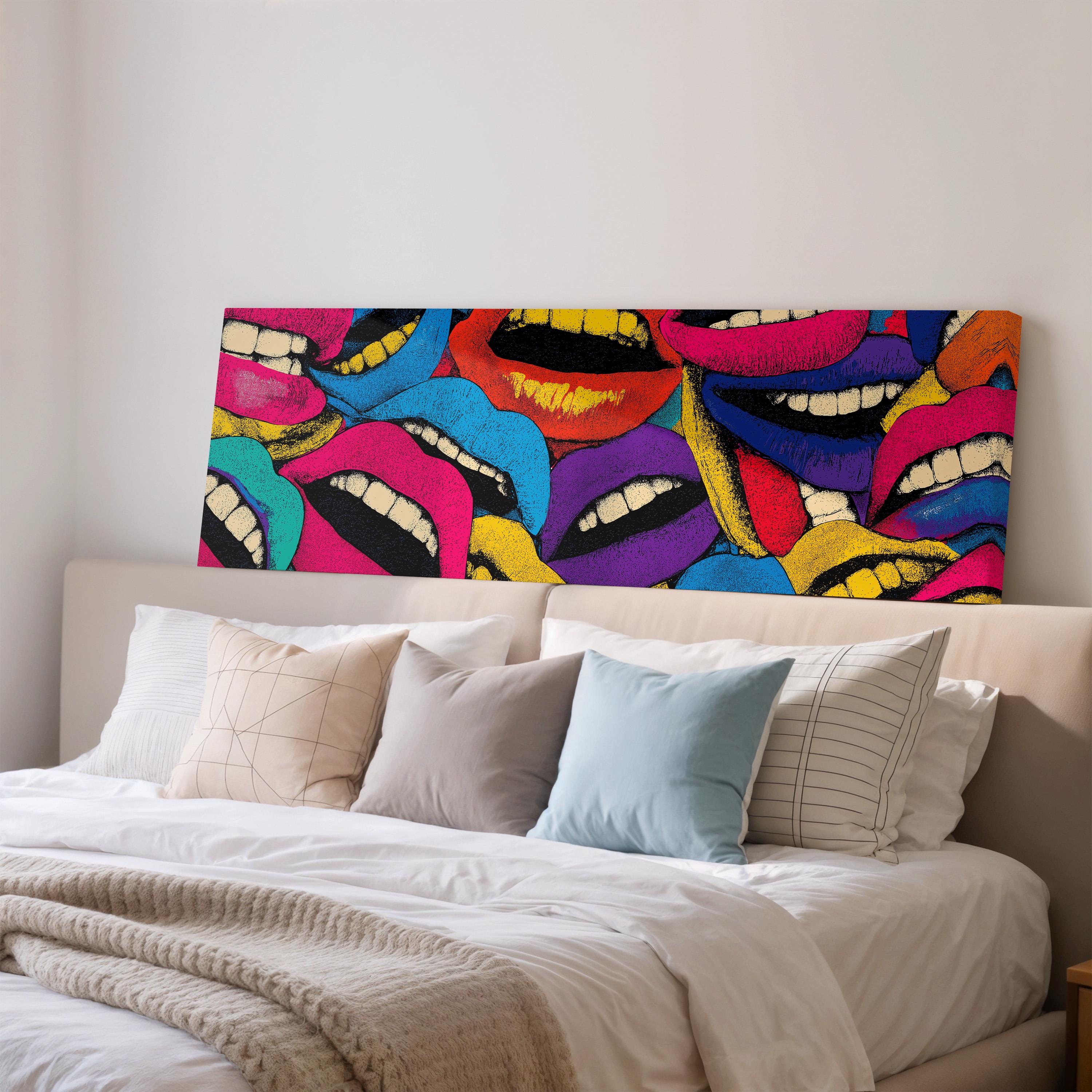 a large, colorful painting of multiple lips on a wall above a bed with white bedding and pillows.