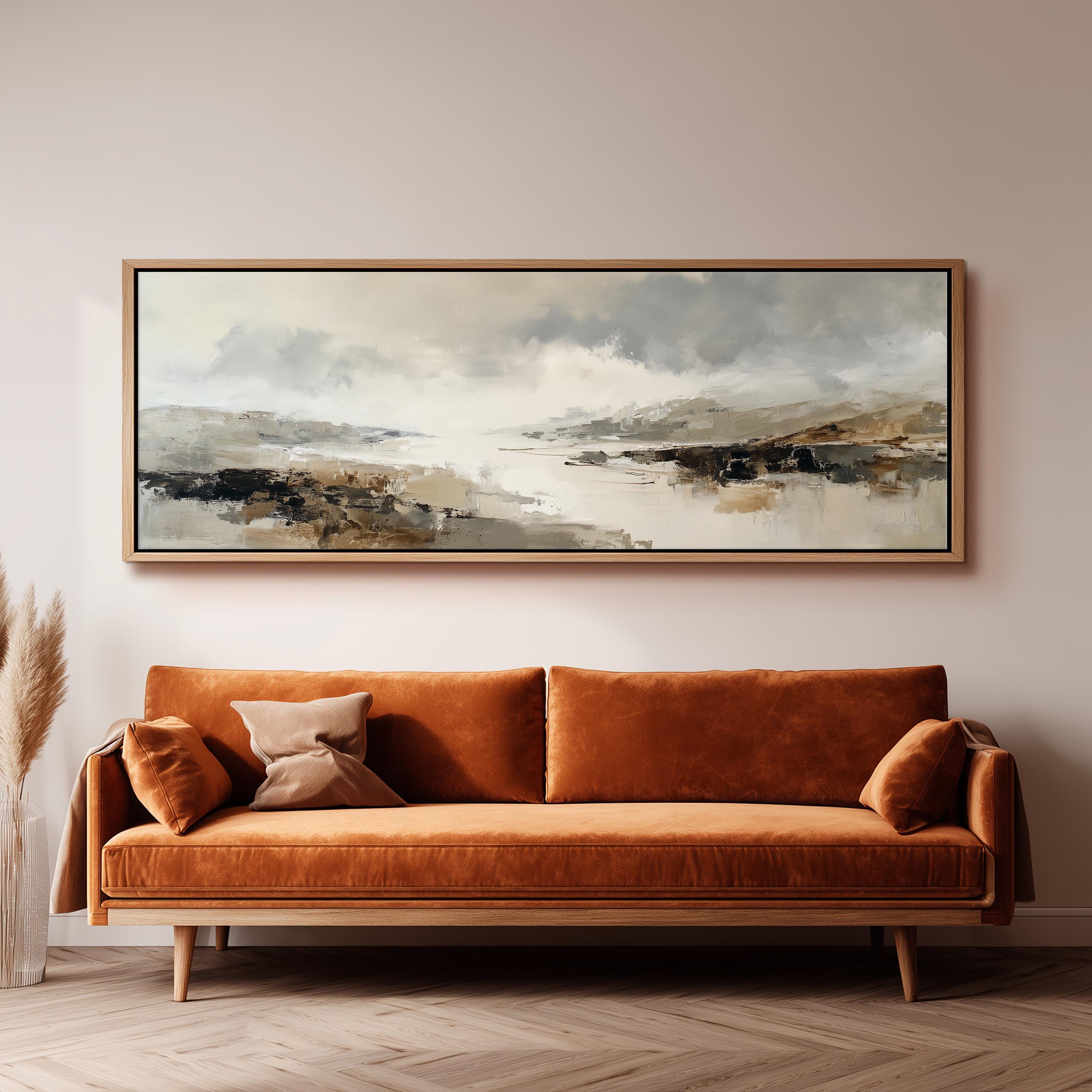 a large, rectangular painting hanging on a wall above a brown sofa with orange cushions.