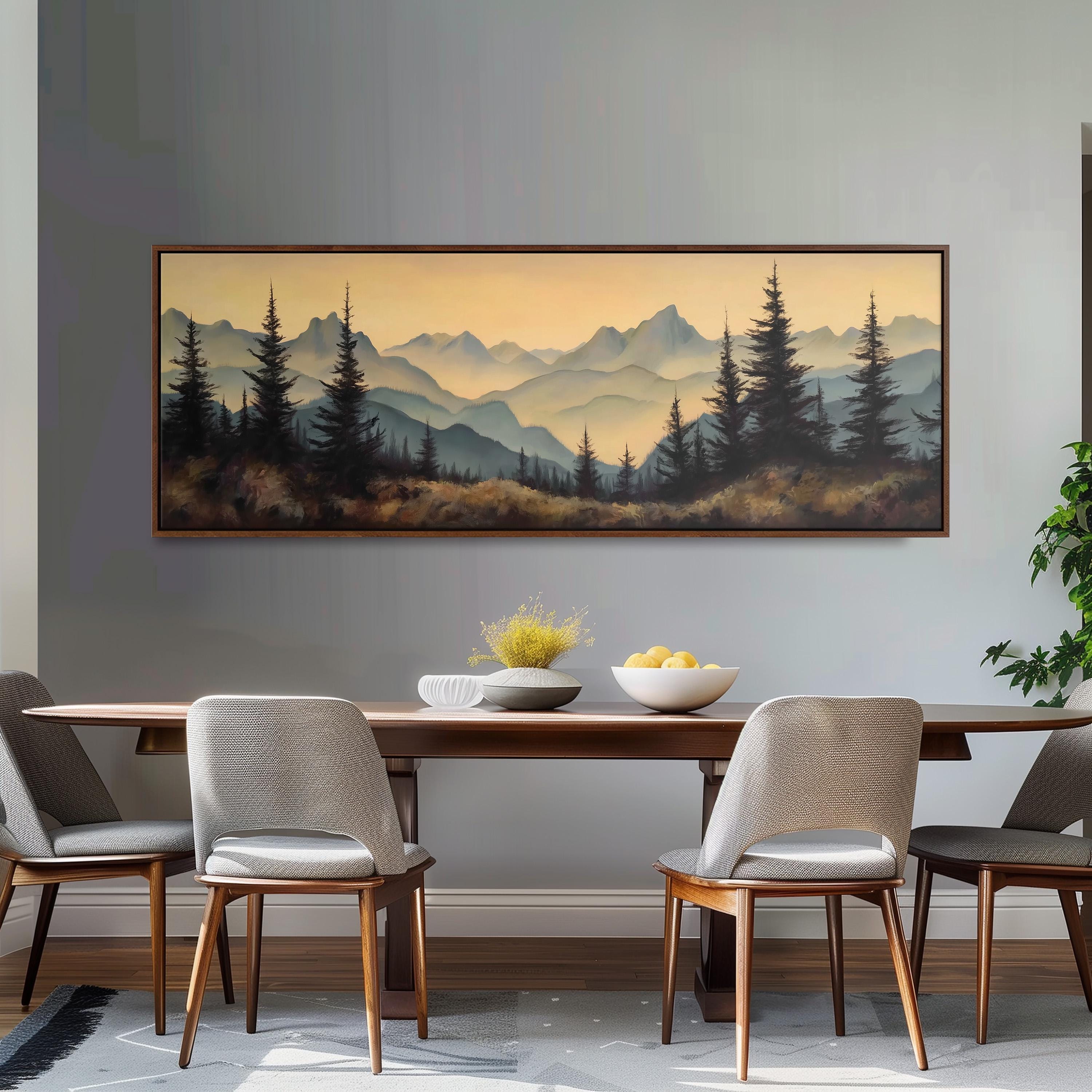 a dining room with a large painting of a mountain landscape hanging on the wall above a wooden dining table with four chairs. The painting depicts a serene mountain scene with pine trees and a warm, golden glow from the setting sun.