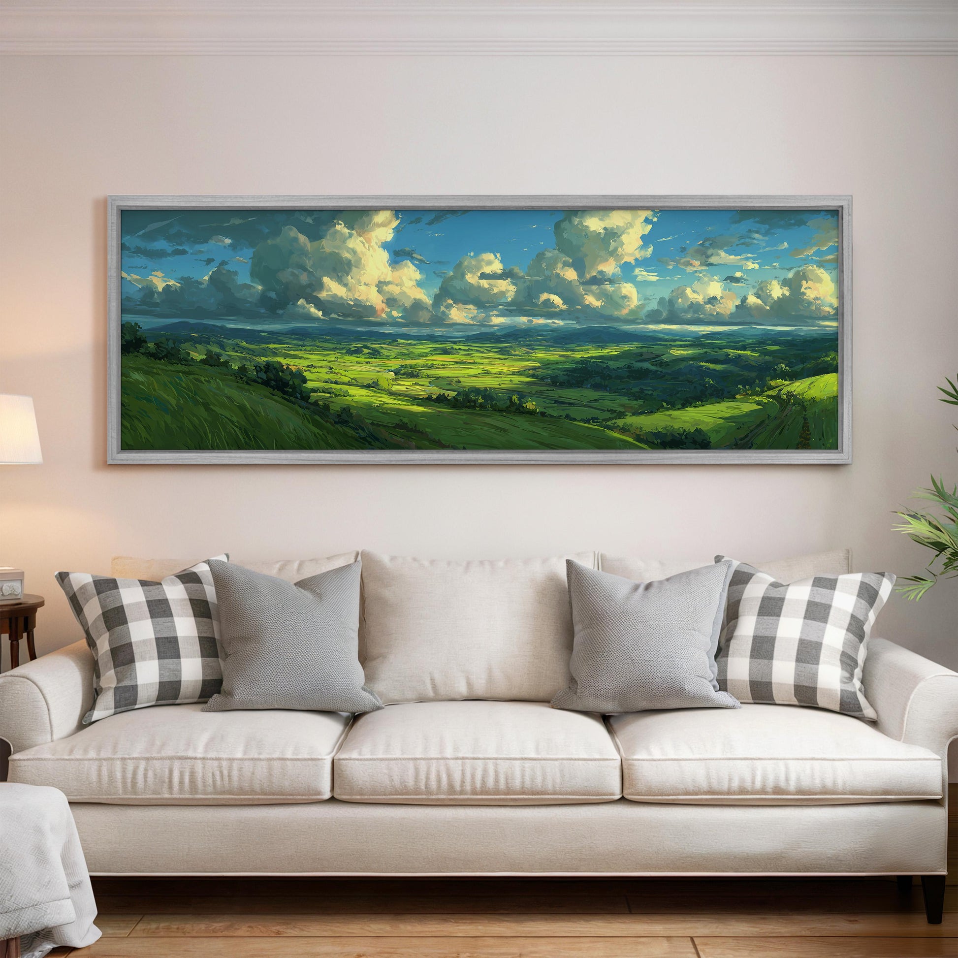 a large, framed landscape painting hanging on a wall above a white sofa with gray and white plaid throw pillows.