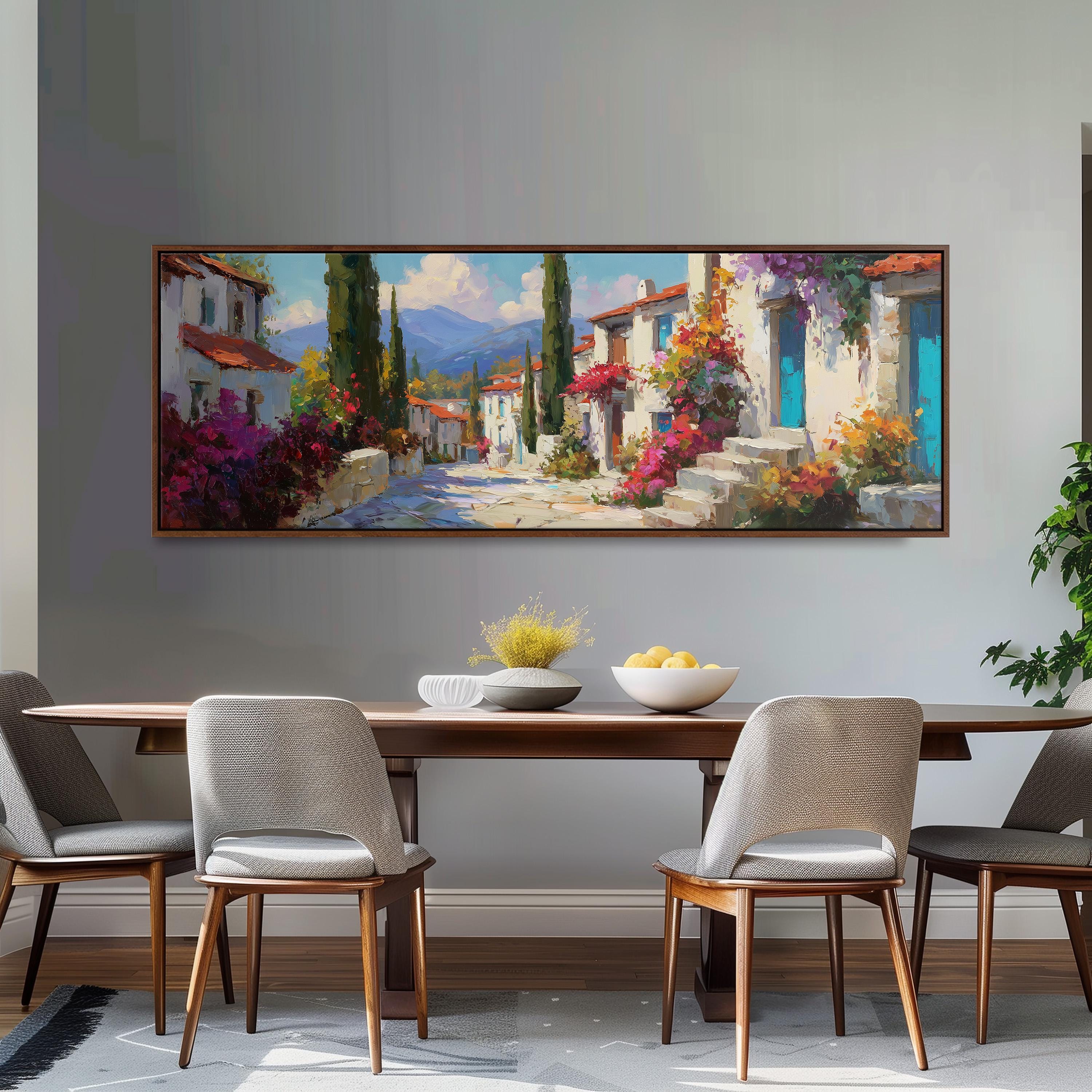 a large painting of a picturesque village scene hanging on a wall above a wooden dining table with four chairs.