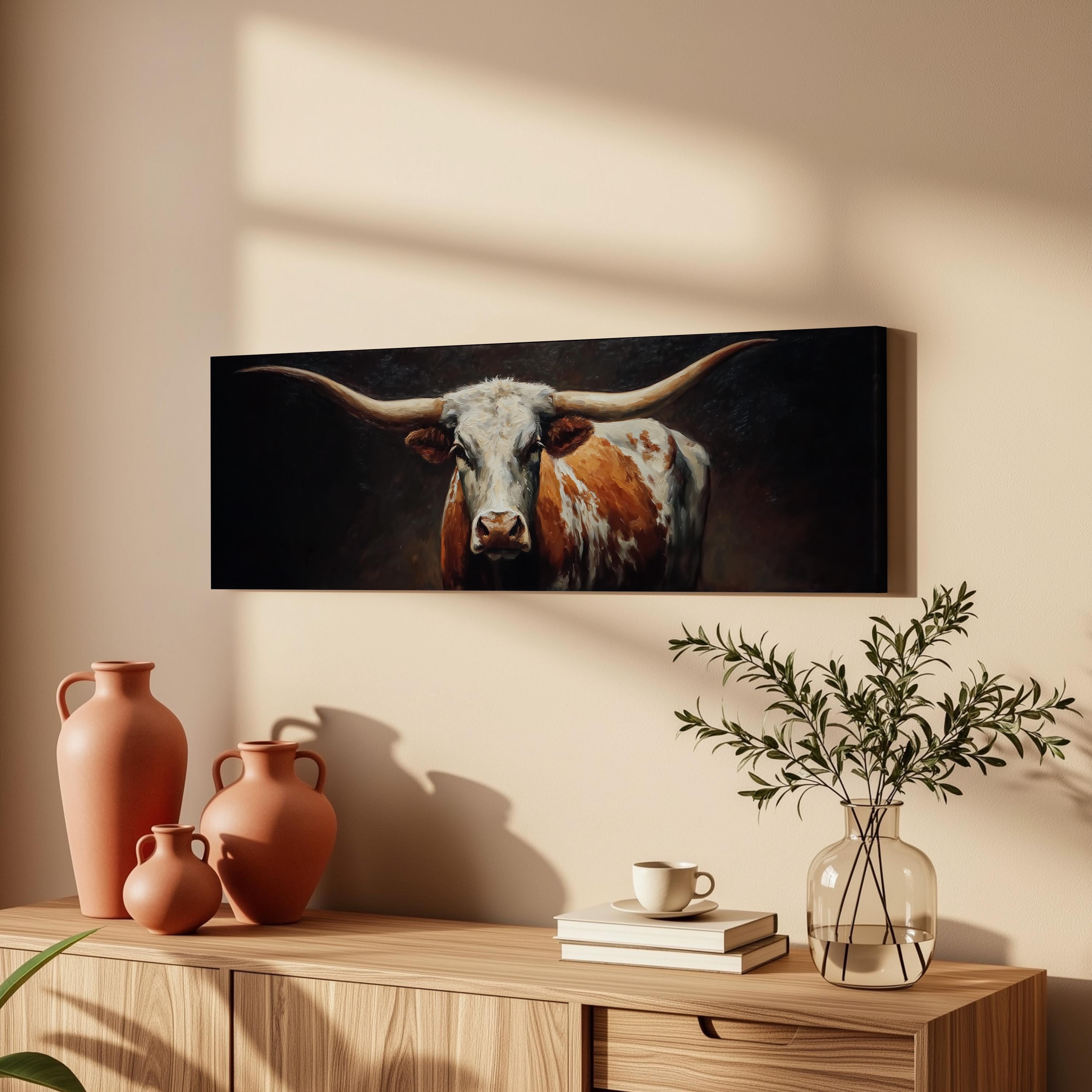 a wooden cabinet with a vase, a plant, and a framed painting of a bull's head on the wall above it.