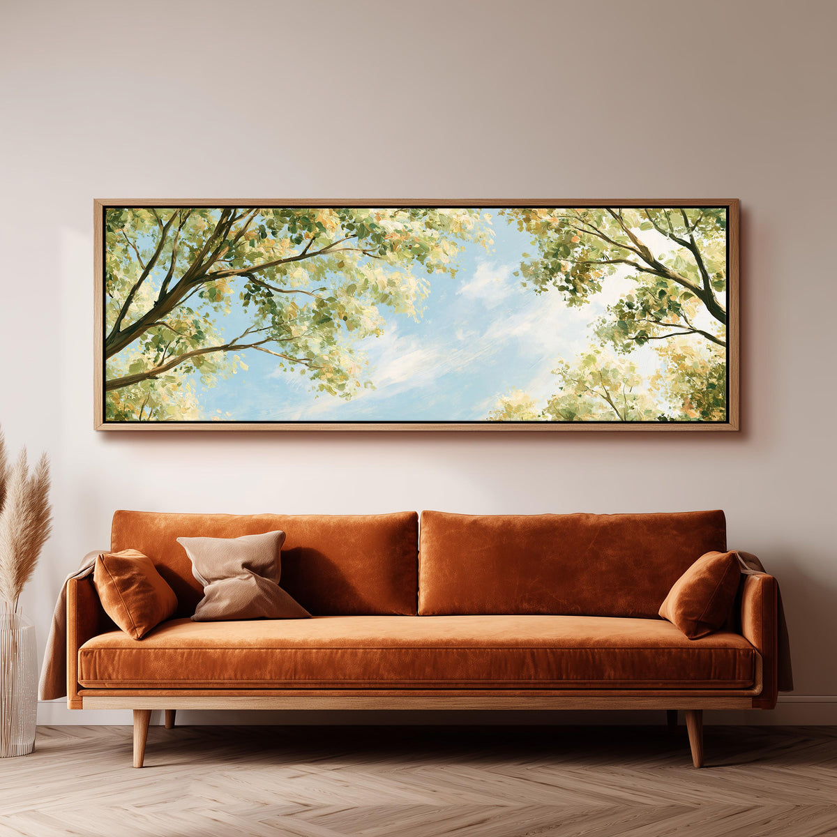 Sunlit leafy branches framing soft clouds panoramic canvas print above a sofa in a living room