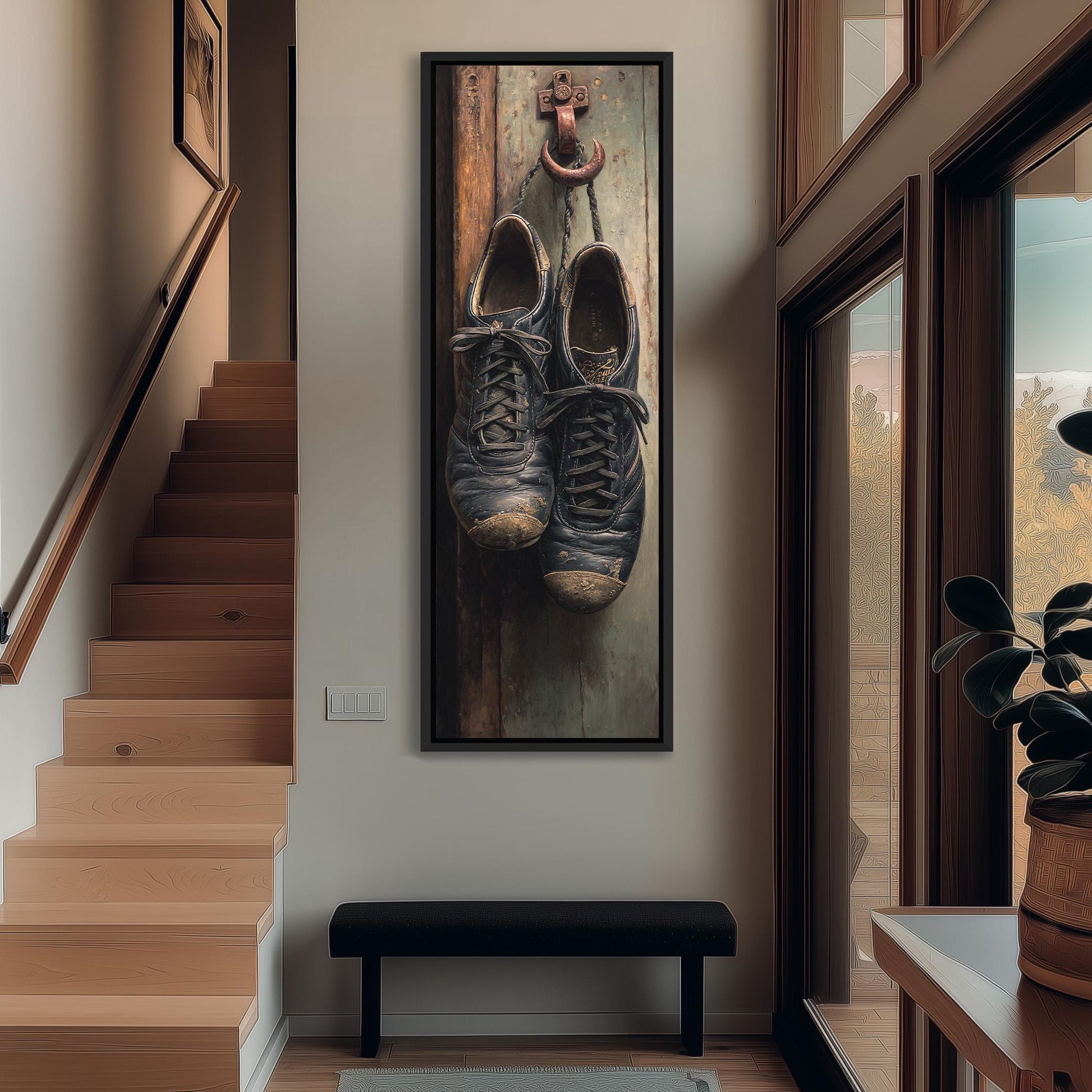 a pair of worn, black shoes hanging on a wooden door, with a black bench in the foreground and a staircase leading to another level in the background.
