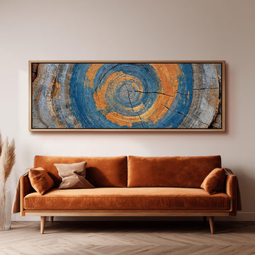 Blue and orange tree ring long horizontal canvas print above a sofa in a living room