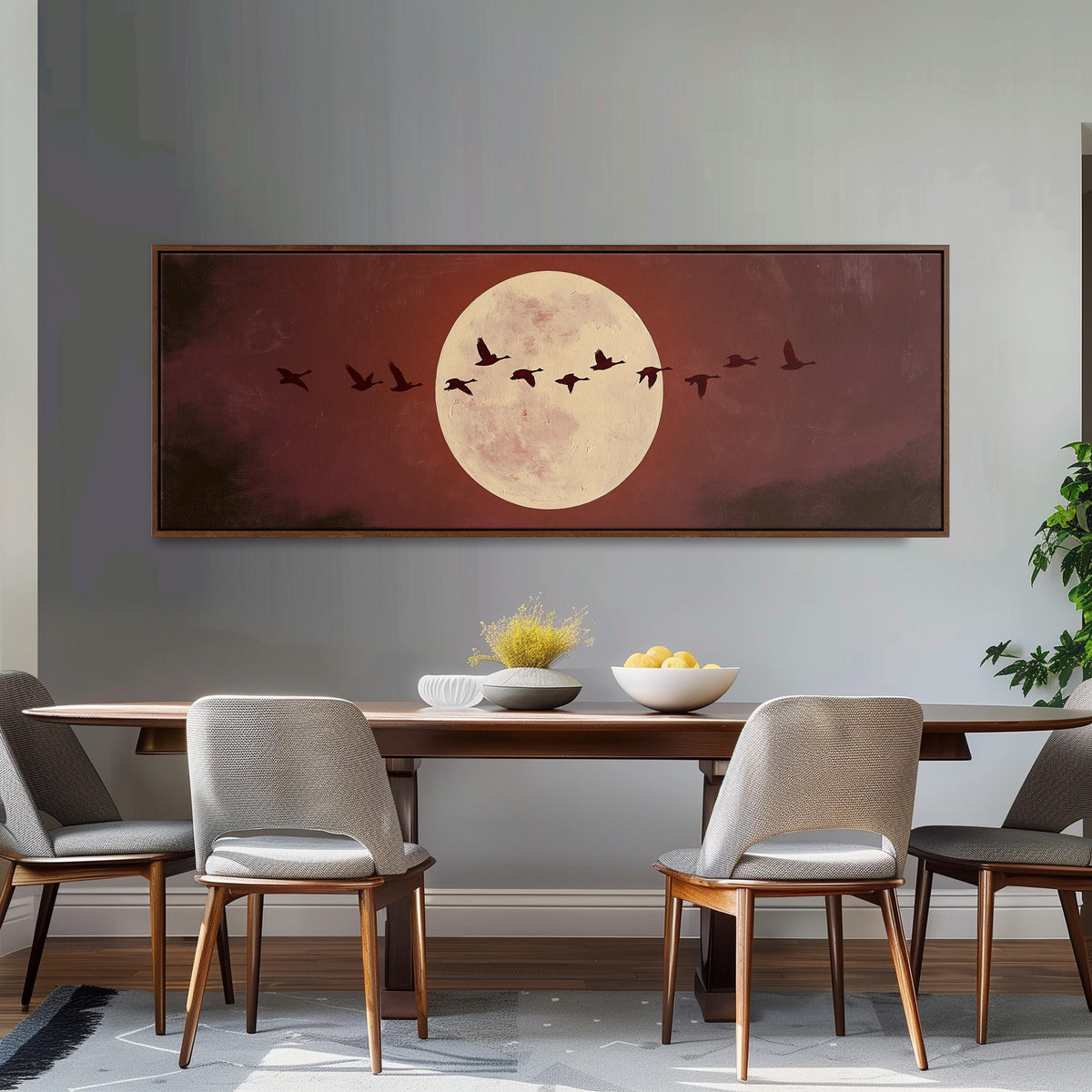 Geese crossing a pale moon on maroon long horizontal canvas print above a dining table