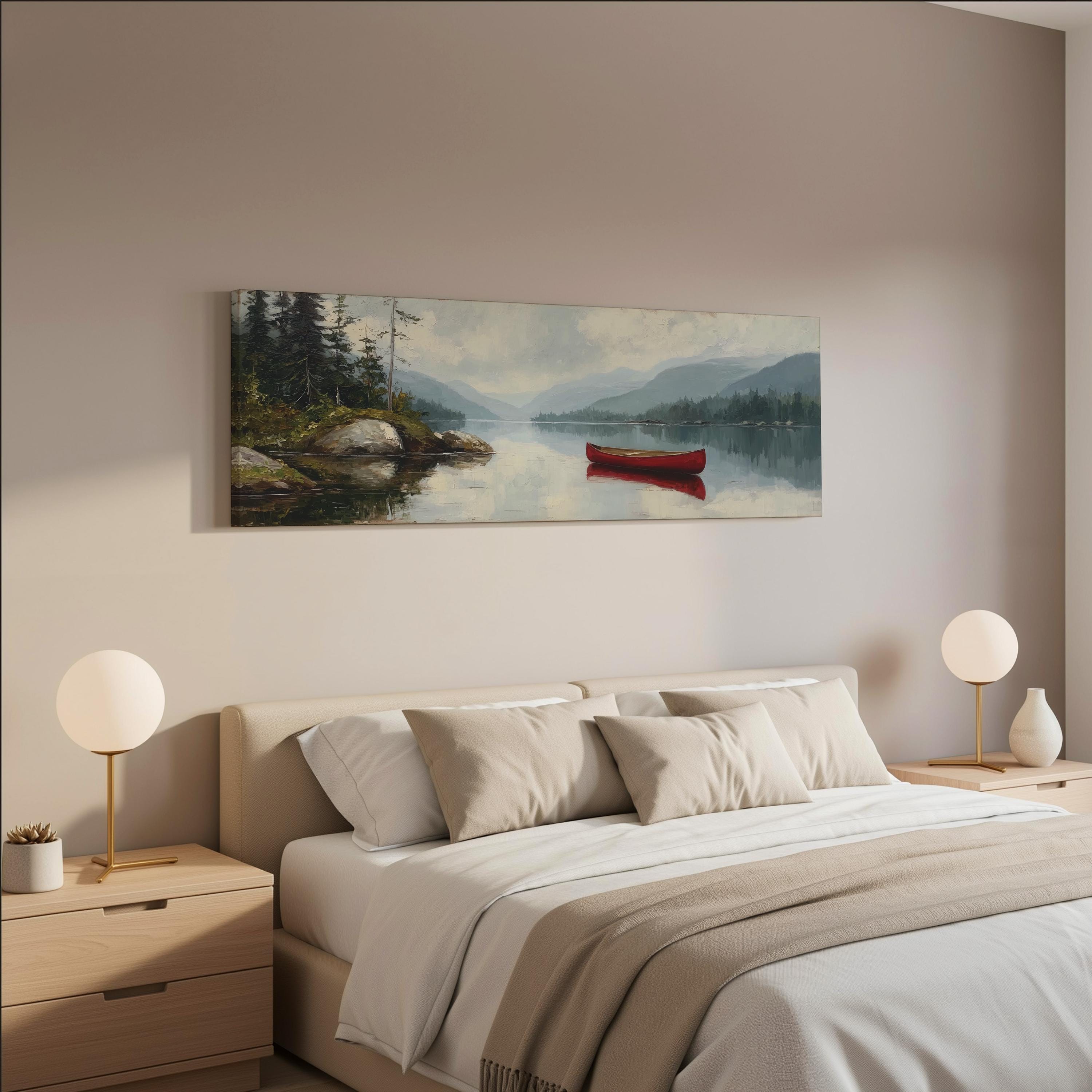 a serene bedroom scene with a large painting of a lake and a red canoe hanging on the wall above a bed with white bedding and beige pillows.