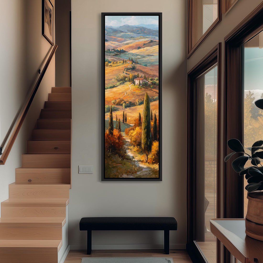 a large framed painting of a picturesque countryside landscape, with rolling hills, trees, and a winding path. The painting is hung on a wall in a room with a window, creating a serene and peaceful atmosphere.