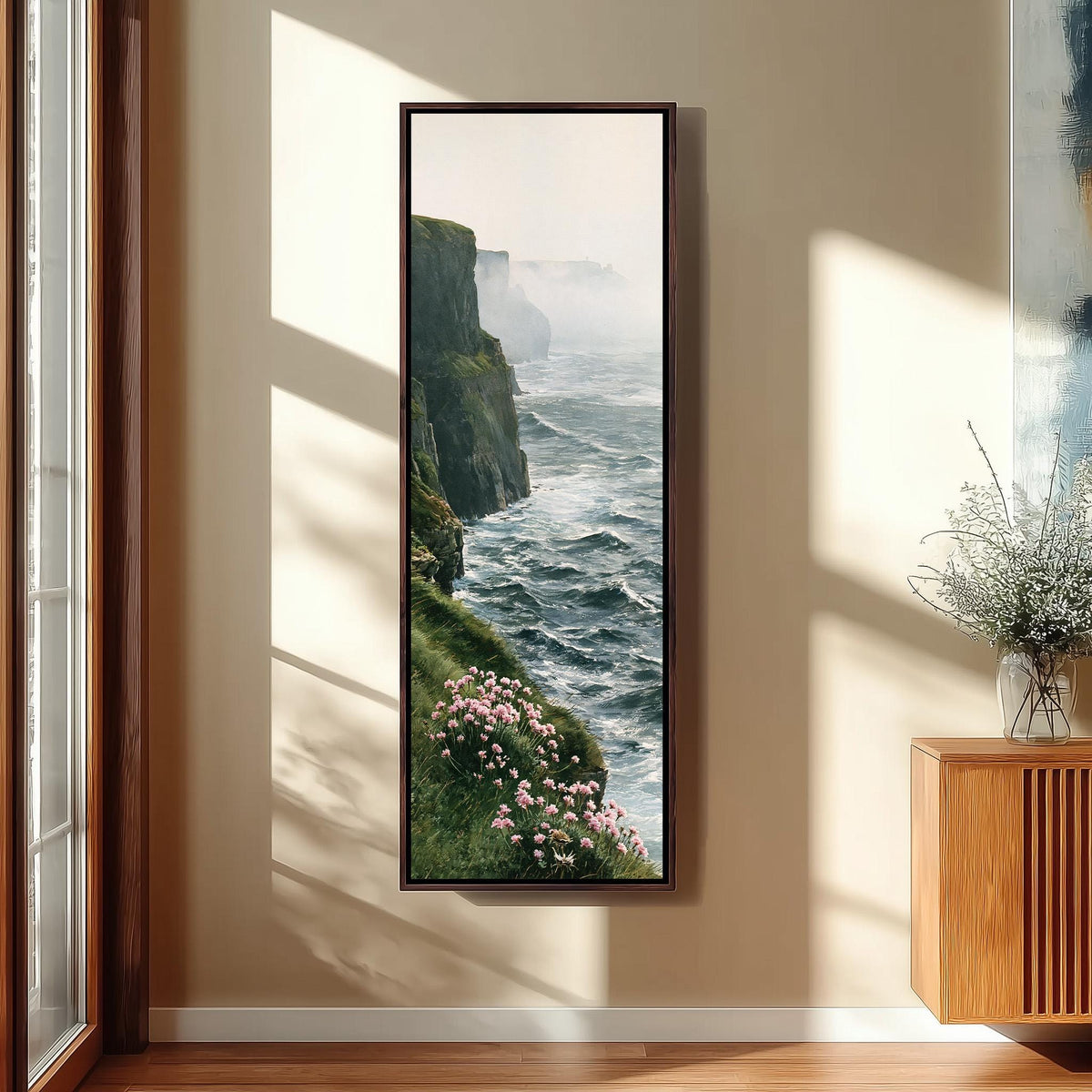 Misty sea cliffs with pink wildflowers long vertical canvas print in a sunlit living space