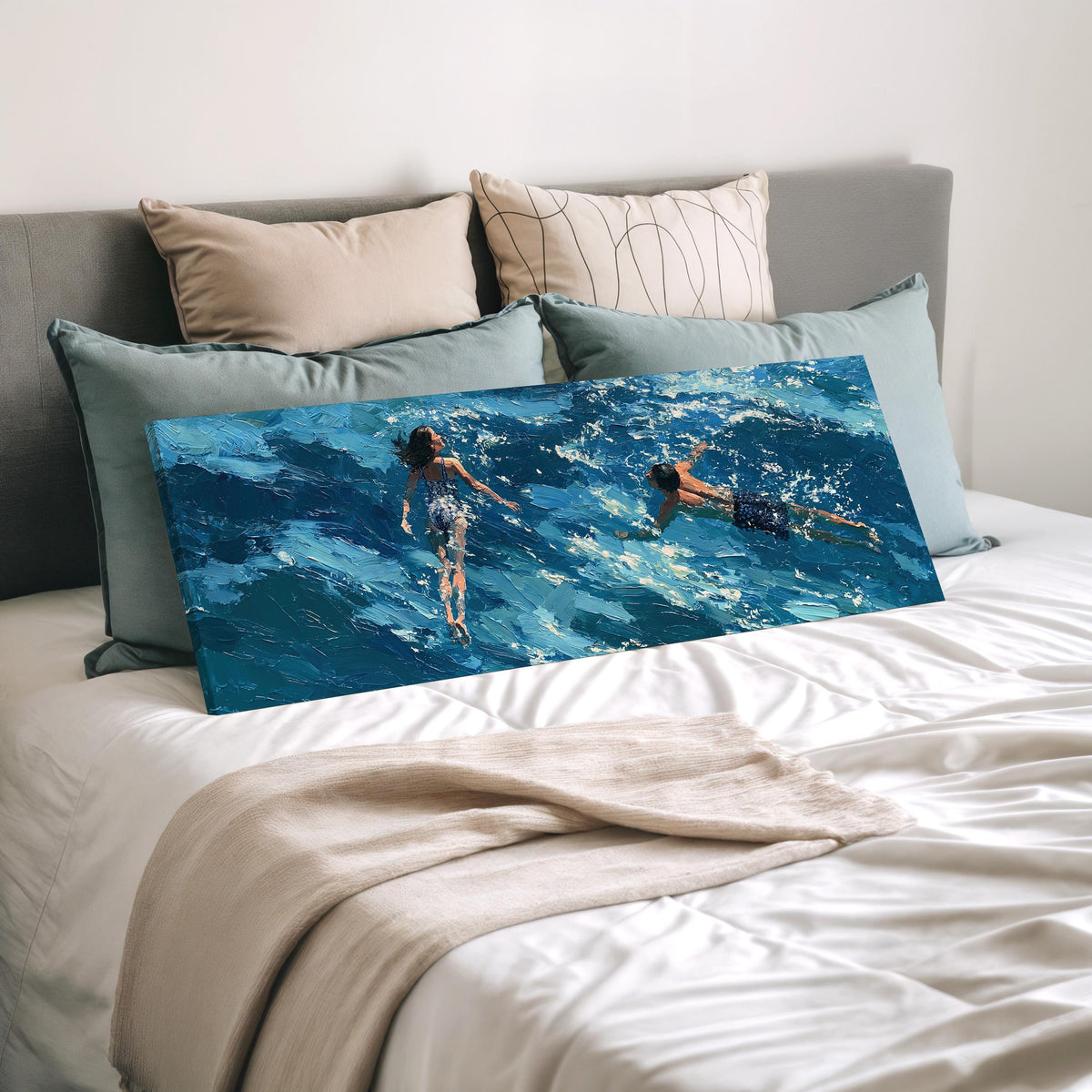 Two swimmers in turquoise waves wide panoramic canvas print laid on a bed to show its size