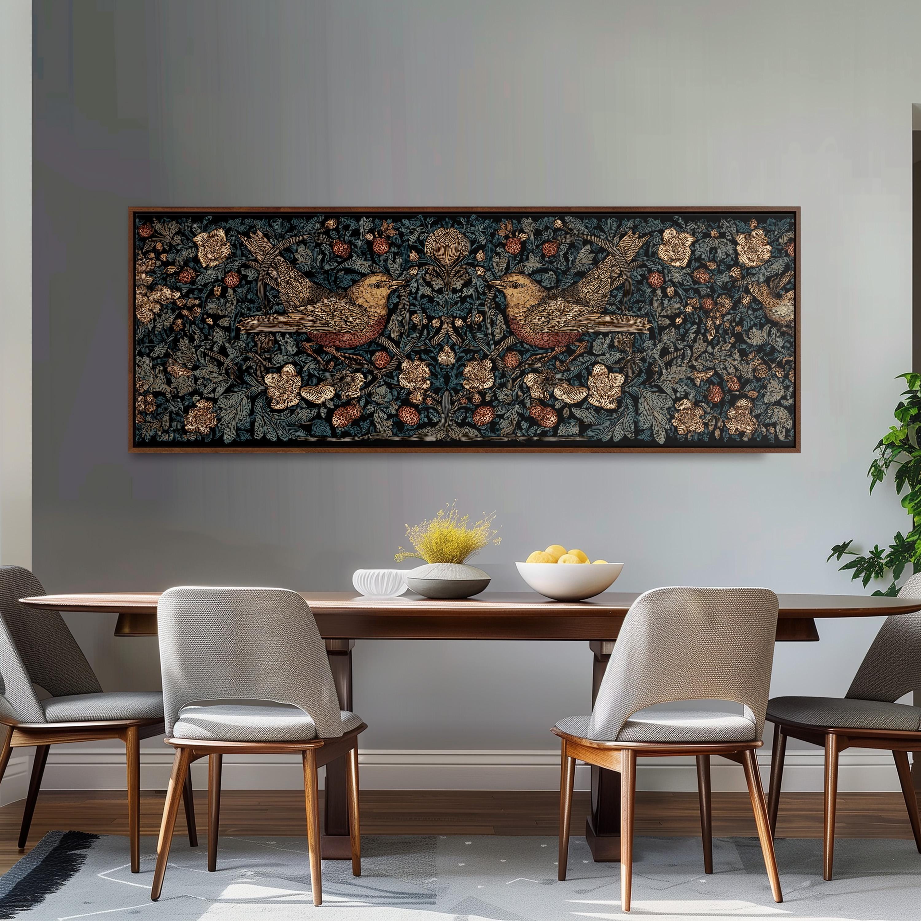 a dining room with a wooden table and four chairs. Above the table, there is a large framed artwork depicting two birds on a floral background. The table is set with a bowl of fruit and a vase of flowers, creating a cozy and inviting atmosphere.