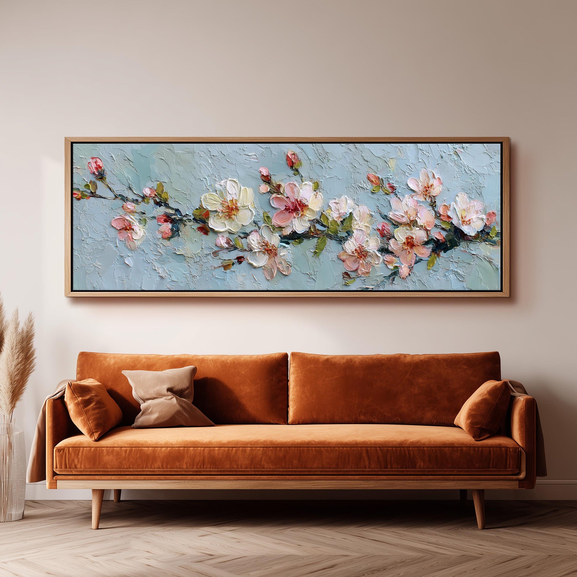 a large painting of flowers hanging on a wall above a brown sofa.