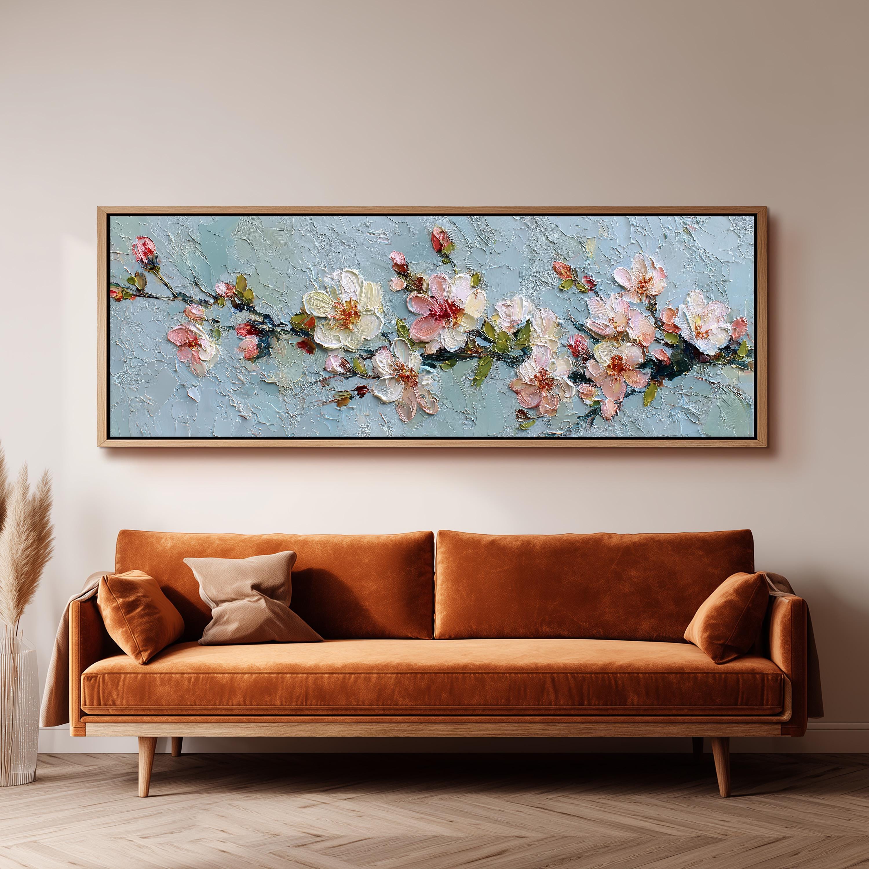 a large painting of flowers hanging on a wall above a brown sofa.