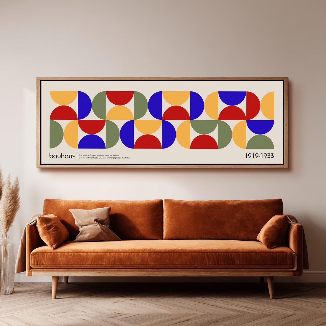 a large abstract painting hanging on a wall above a brown sofa with a pillow.
