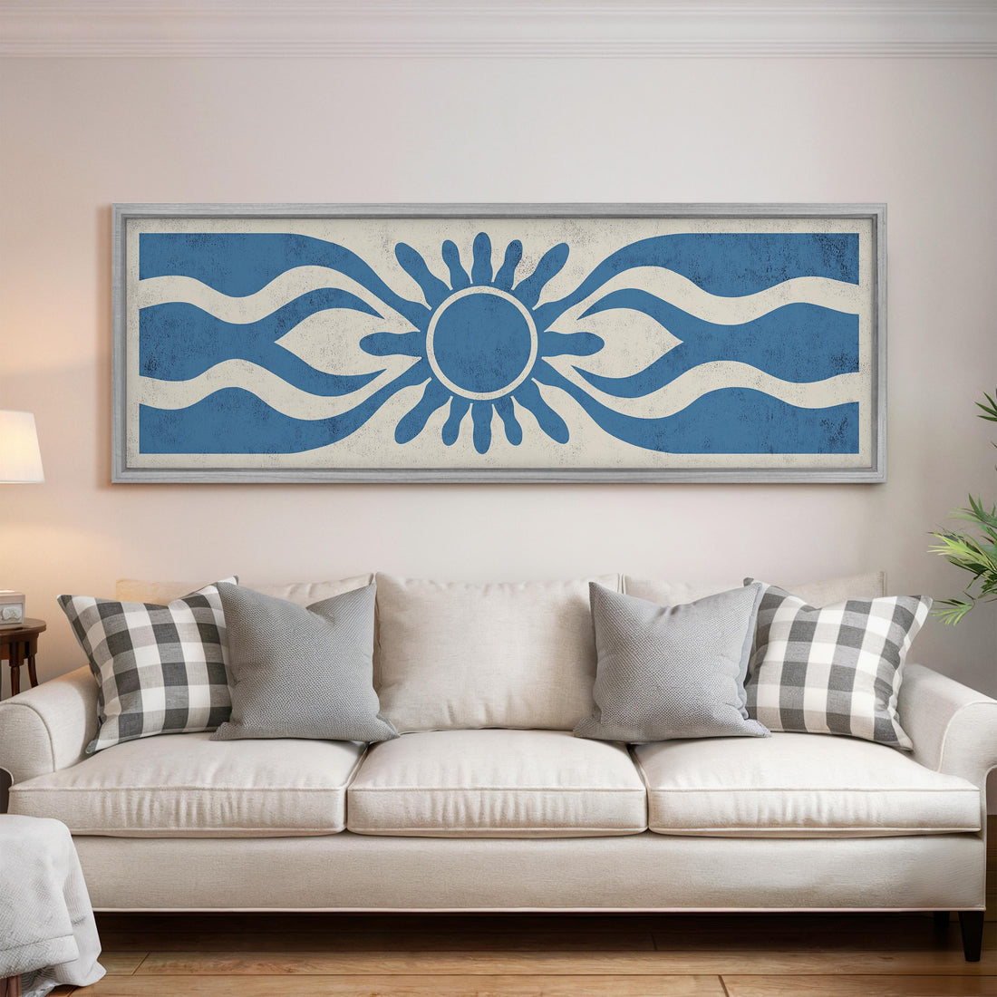 a large blue and white abstract artwork hanging on a wall above a white couch with gray and white plaid throw pillows.