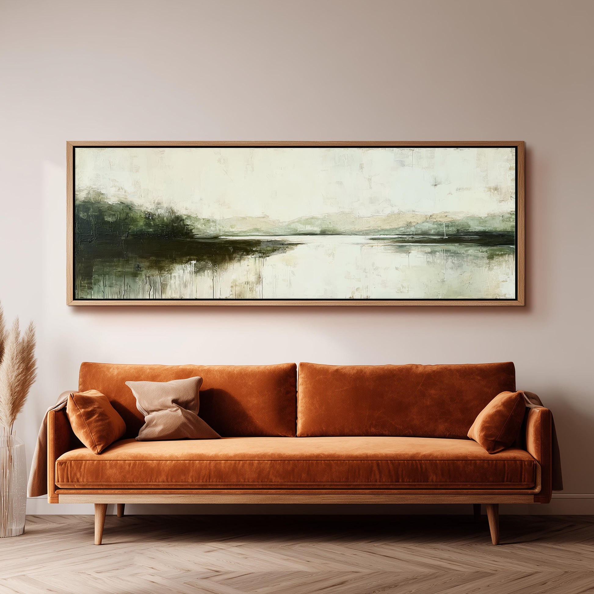 a large, rectangular painting hanging on a wall above a brown sofa with orange cushions.
