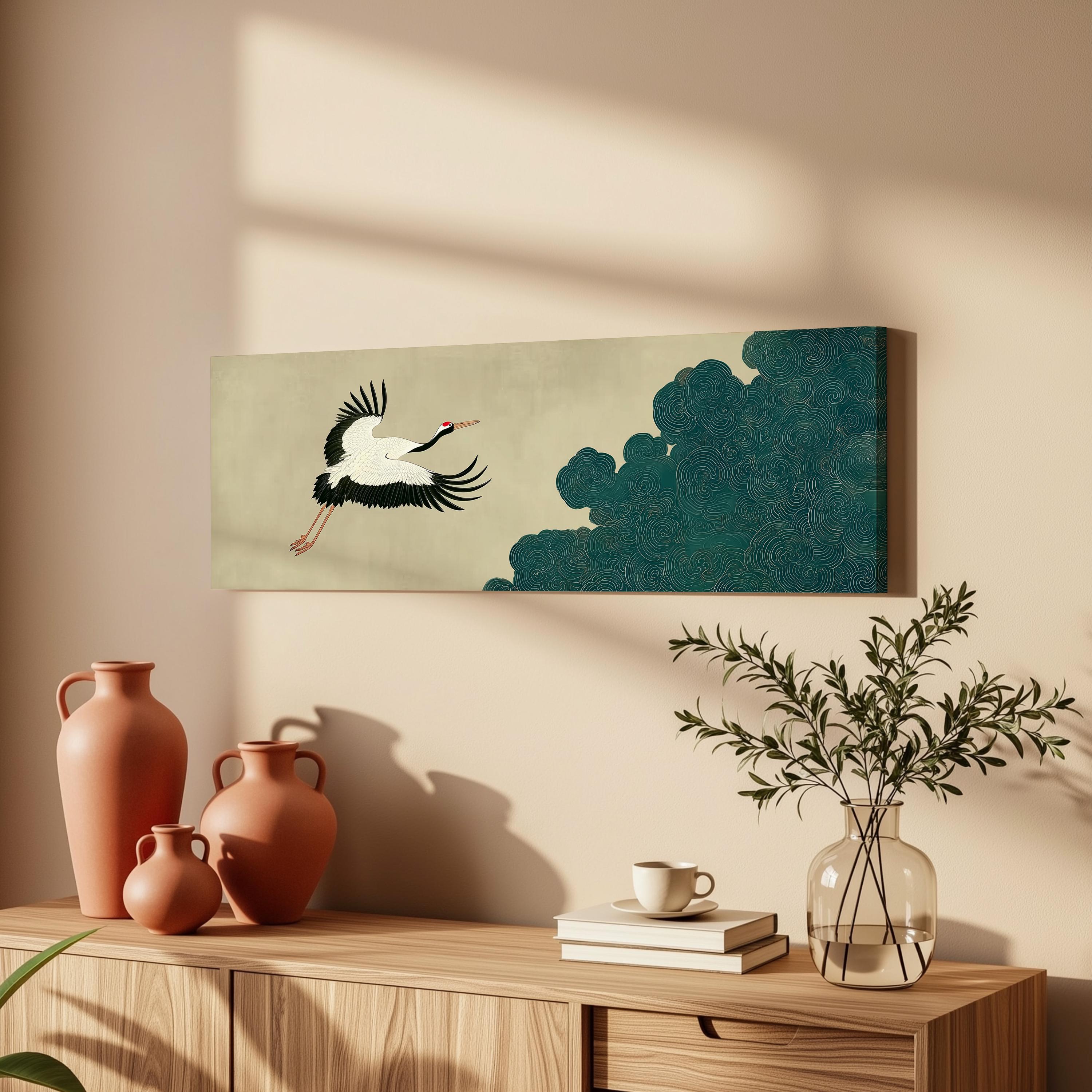 a wooden cabinet with a vase, a coffee cup, and a stack of books on top. Above the cabinet, there is a framed artwork depicting a crane in flight.