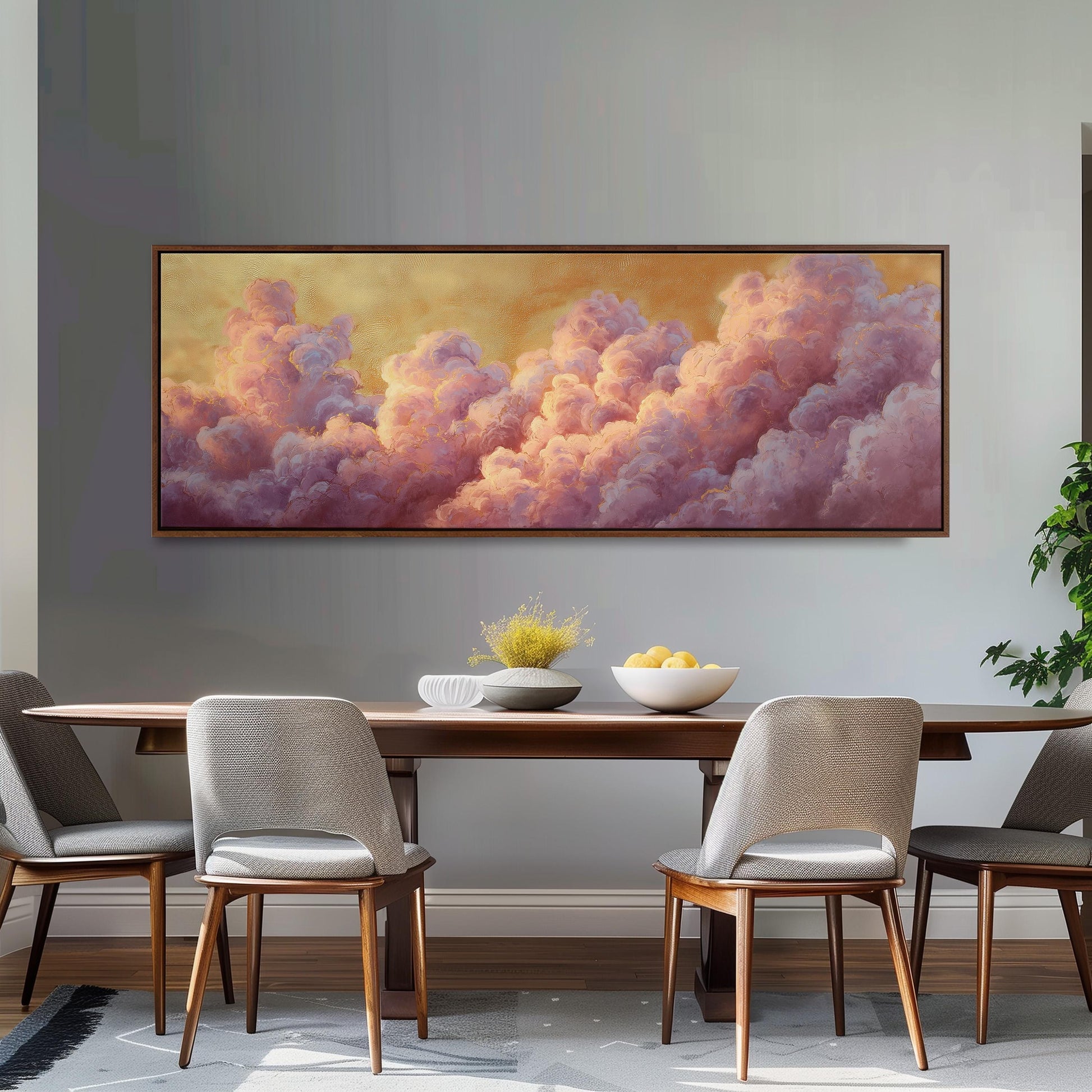 a dining room with a large painting of clouds hanging on the wall above a wooden table with four chairs. The painting has a warm, golden hue and depicts a serene, cloud-filled sky.