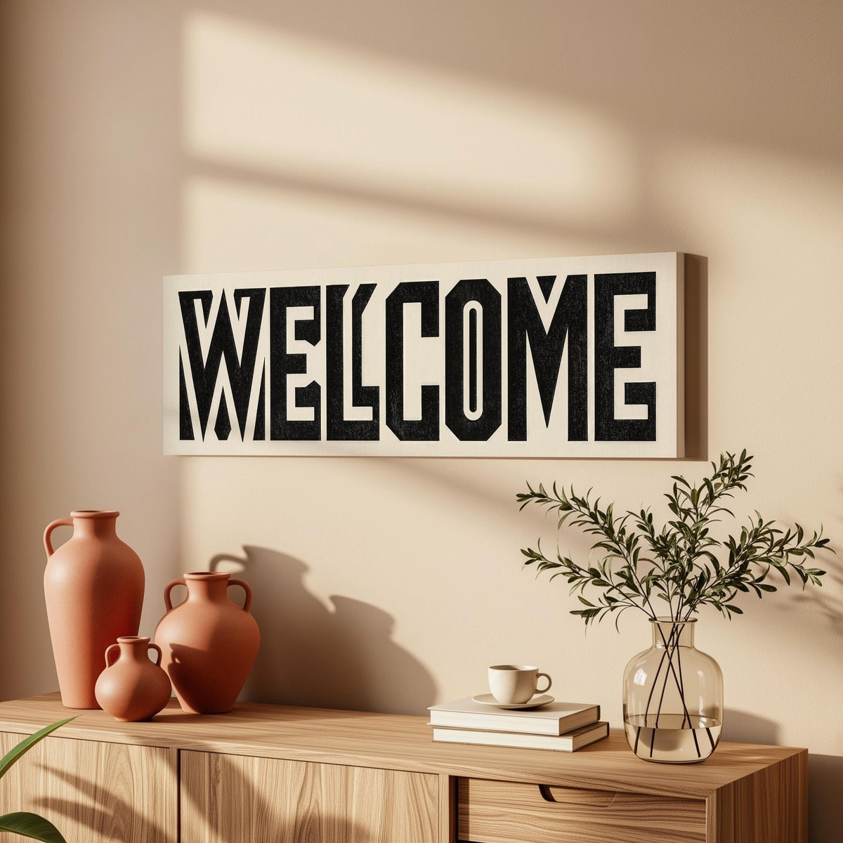 Bold welcome block letters long horizontal canvas print above a wooden sideboard