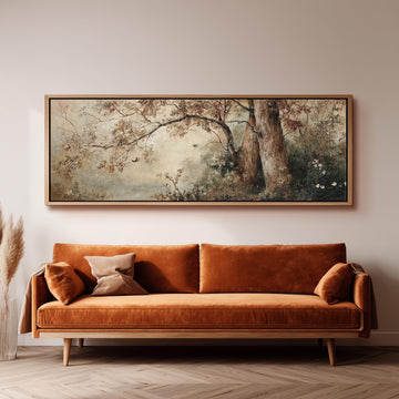 a large, framed painting of a tree and foliage hanging on a wall above a brown sofa with orange cushions.