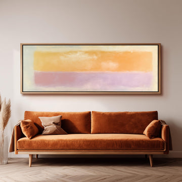 a large, rectangular painting hanging on a wall above a brown sofa with two pillows.