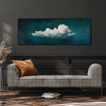 a black and white checkered sofa with a brown throw pillow, positioned in front of a large framed picture of a cloud on a dark wall.