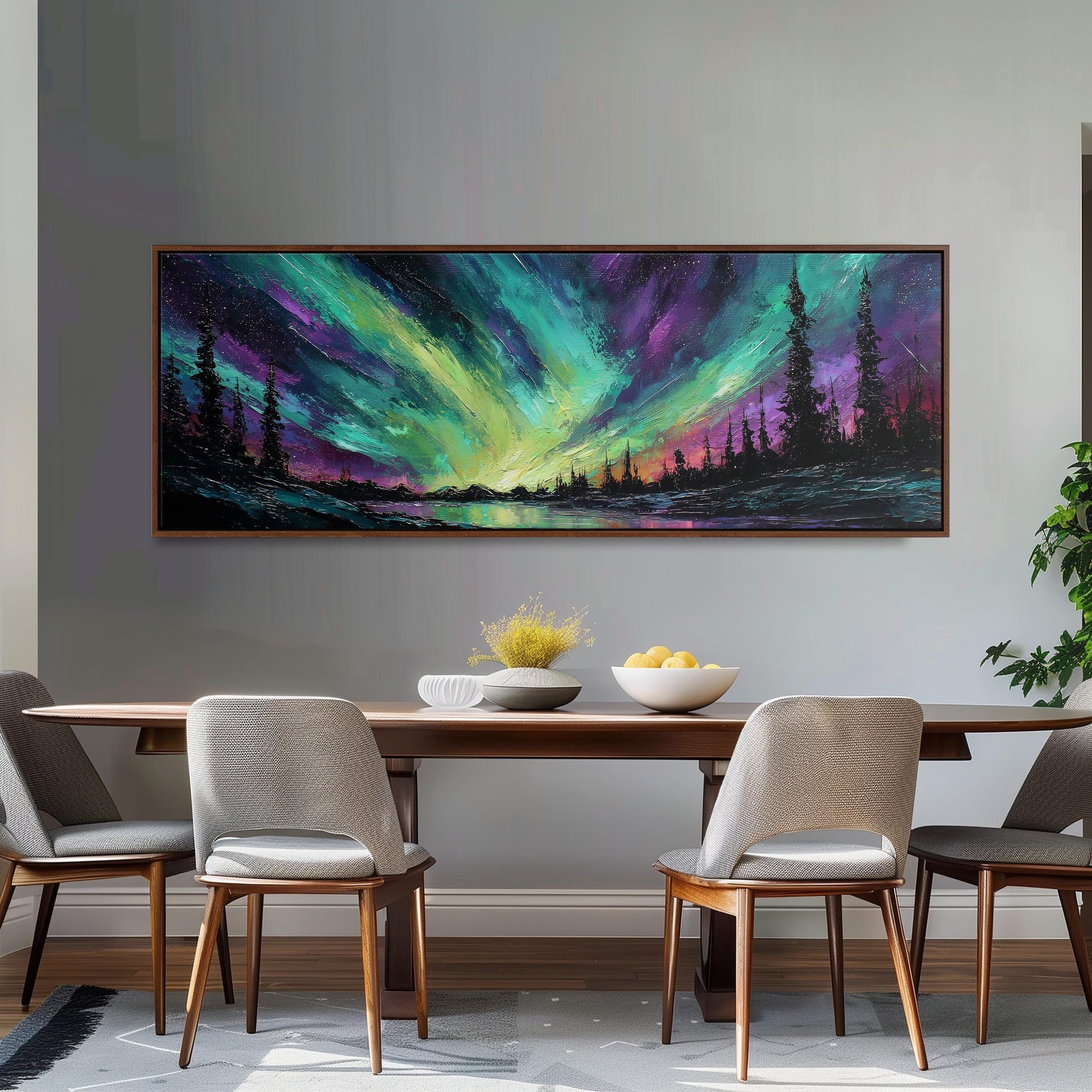 a dining room with a large painting of a landscape hanging on the wall above a wooden table with four chairs. The painting depicts a serene scene of a forest under a colorful, vibrant sky, creating a peaceful and inviting atmosphere.