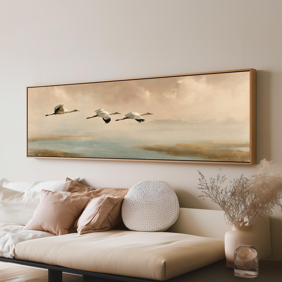 Cranes flying over a calm shore at dusk long horizontal canvas print above a sofa in a living room