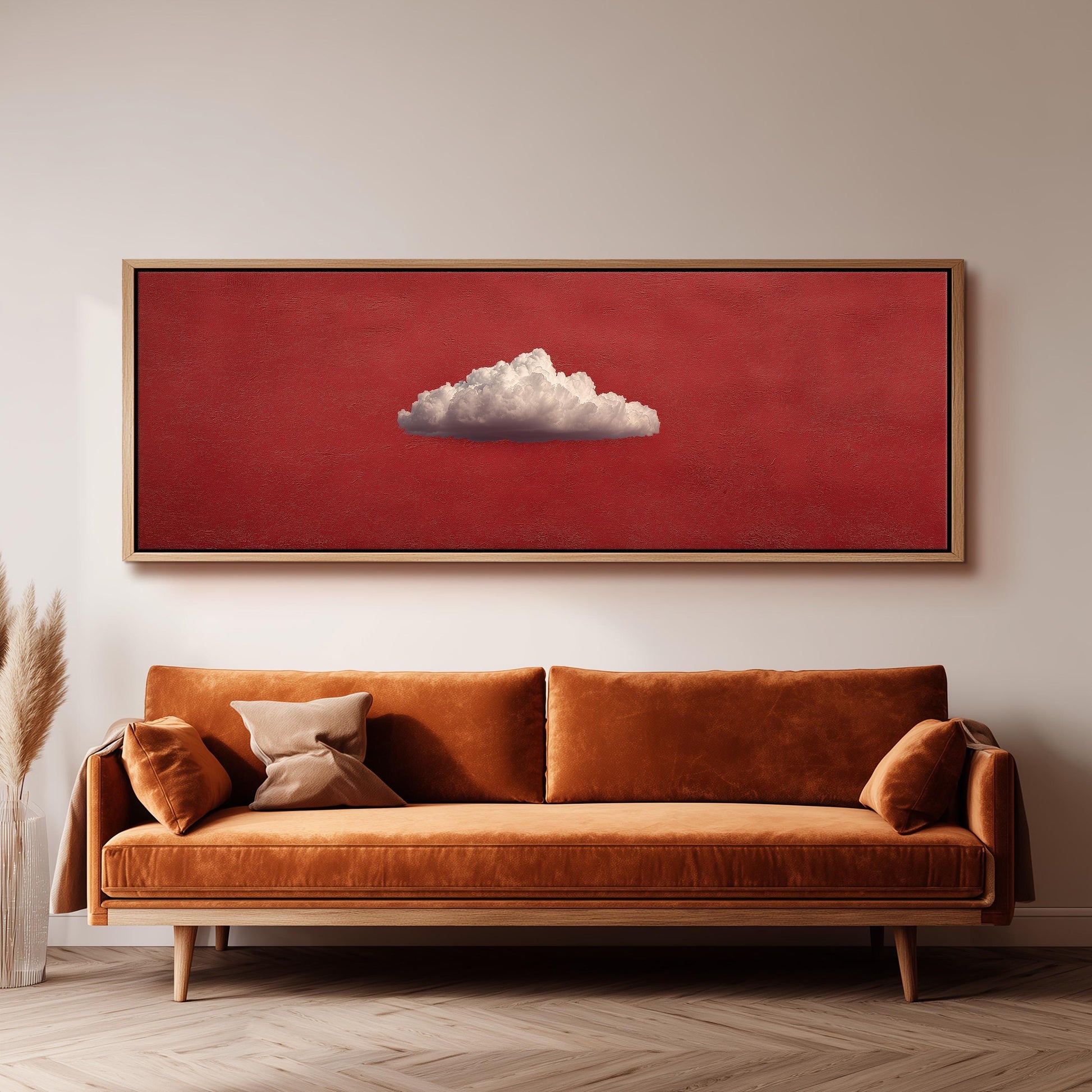 a large red painting hanging on a white wall above a brown sofa with two pillows.