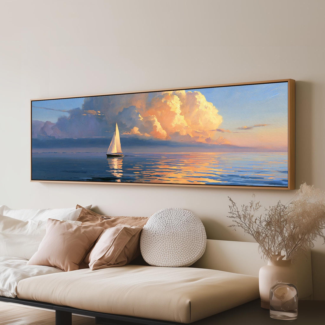 Sailboat at sunset under golden clouds long horizontal canvas print above a sofa in a living room