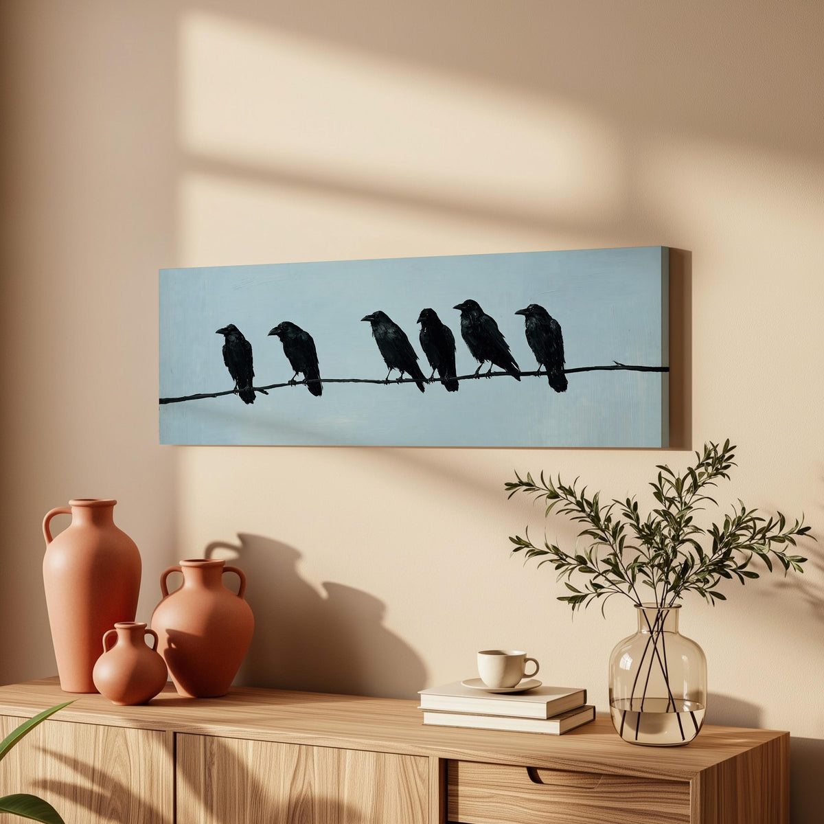Ravens spaced along a wire long horizontal canvas print above a wooden sideboard