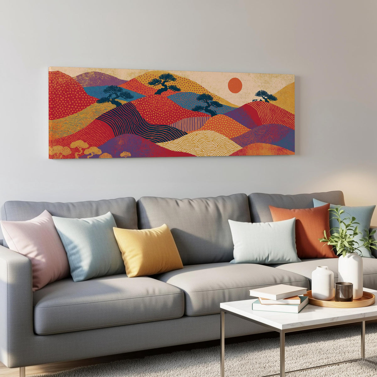 Bonsai trees on patterned hills with a red sun panoramic canvas print above a grey sofa in a living room