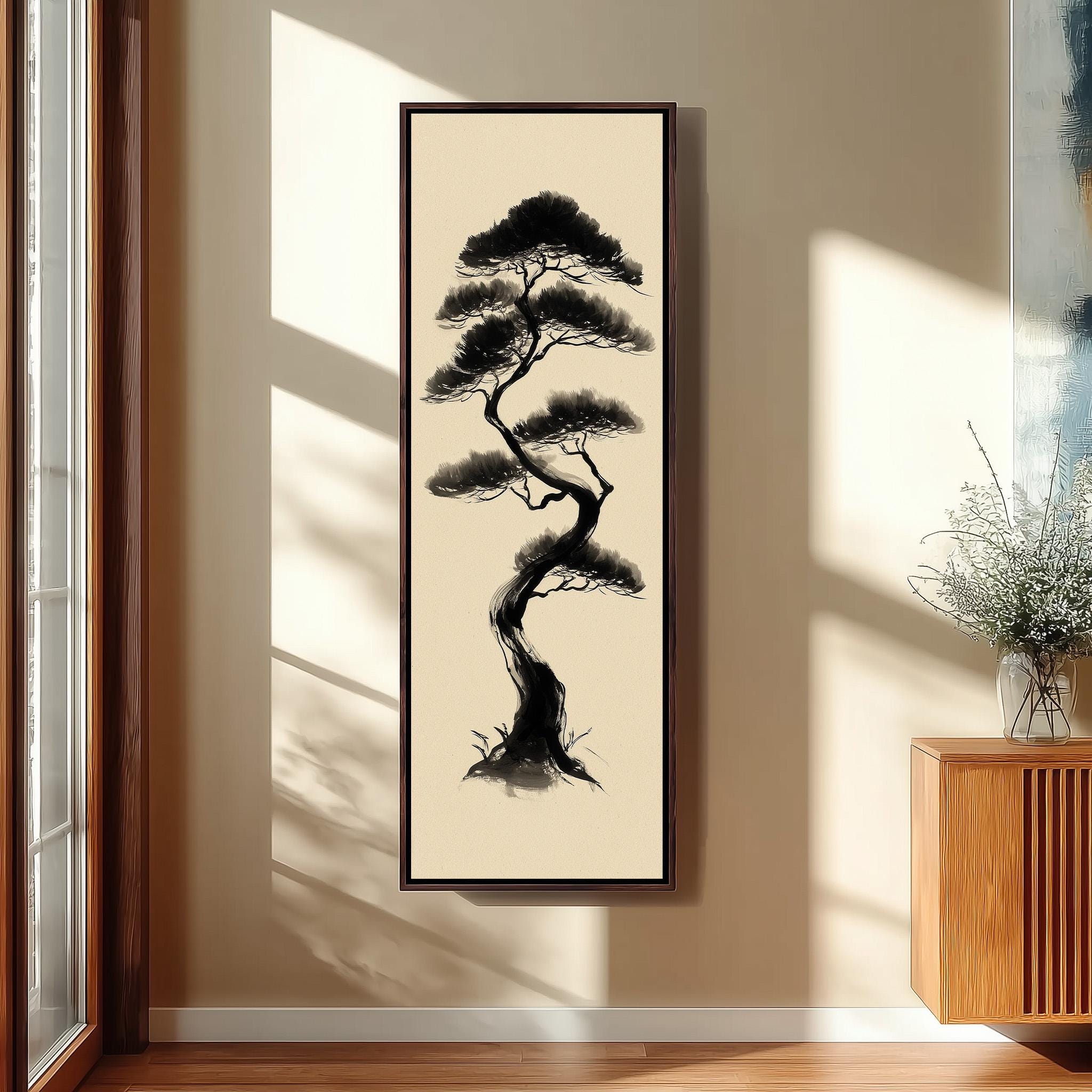 a large black and white painting of a tree hanging on a wall in a room with a wooden floor and a window.