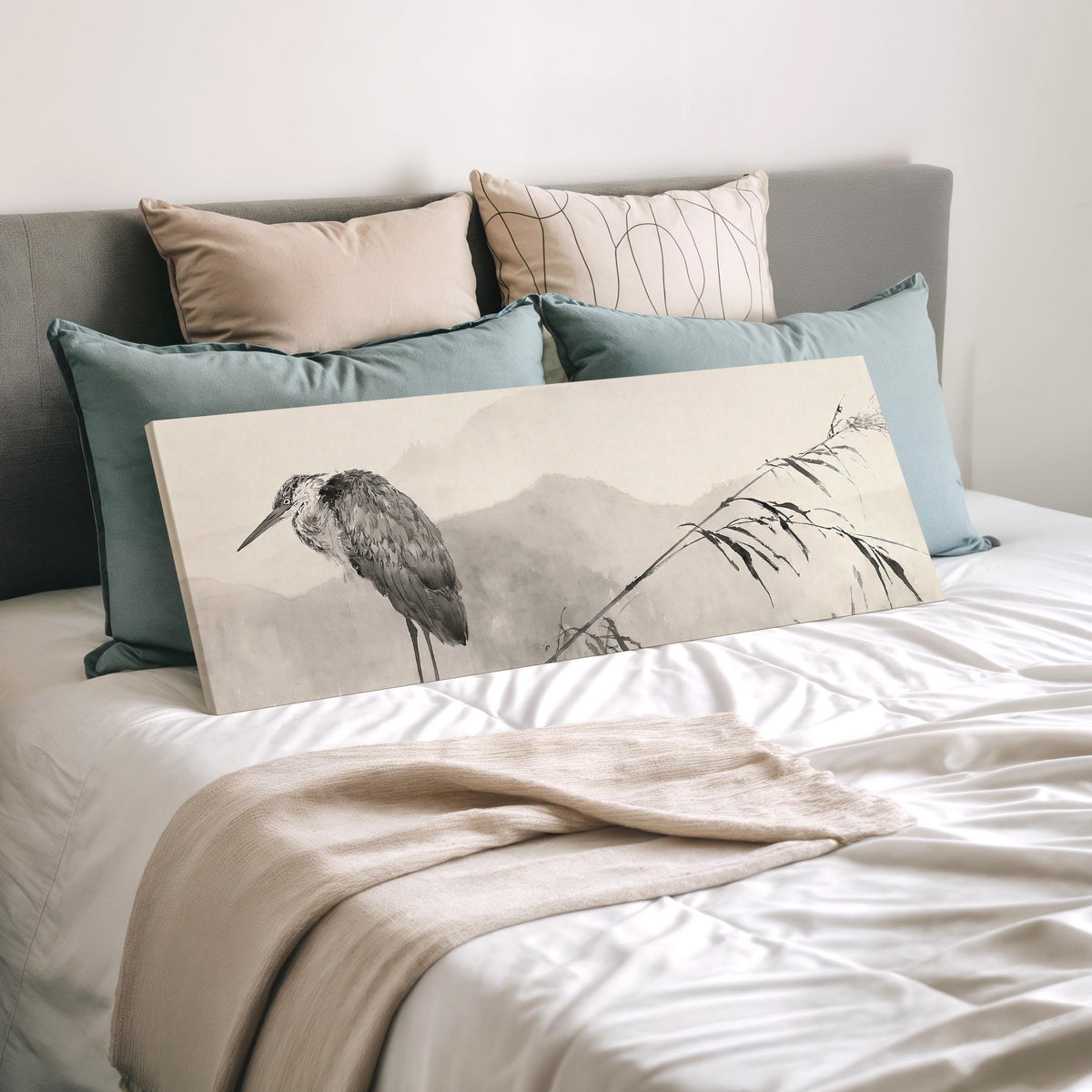 Heron in front of misty ink mountains wide panoramic canvas print laid on a bed to show its size
