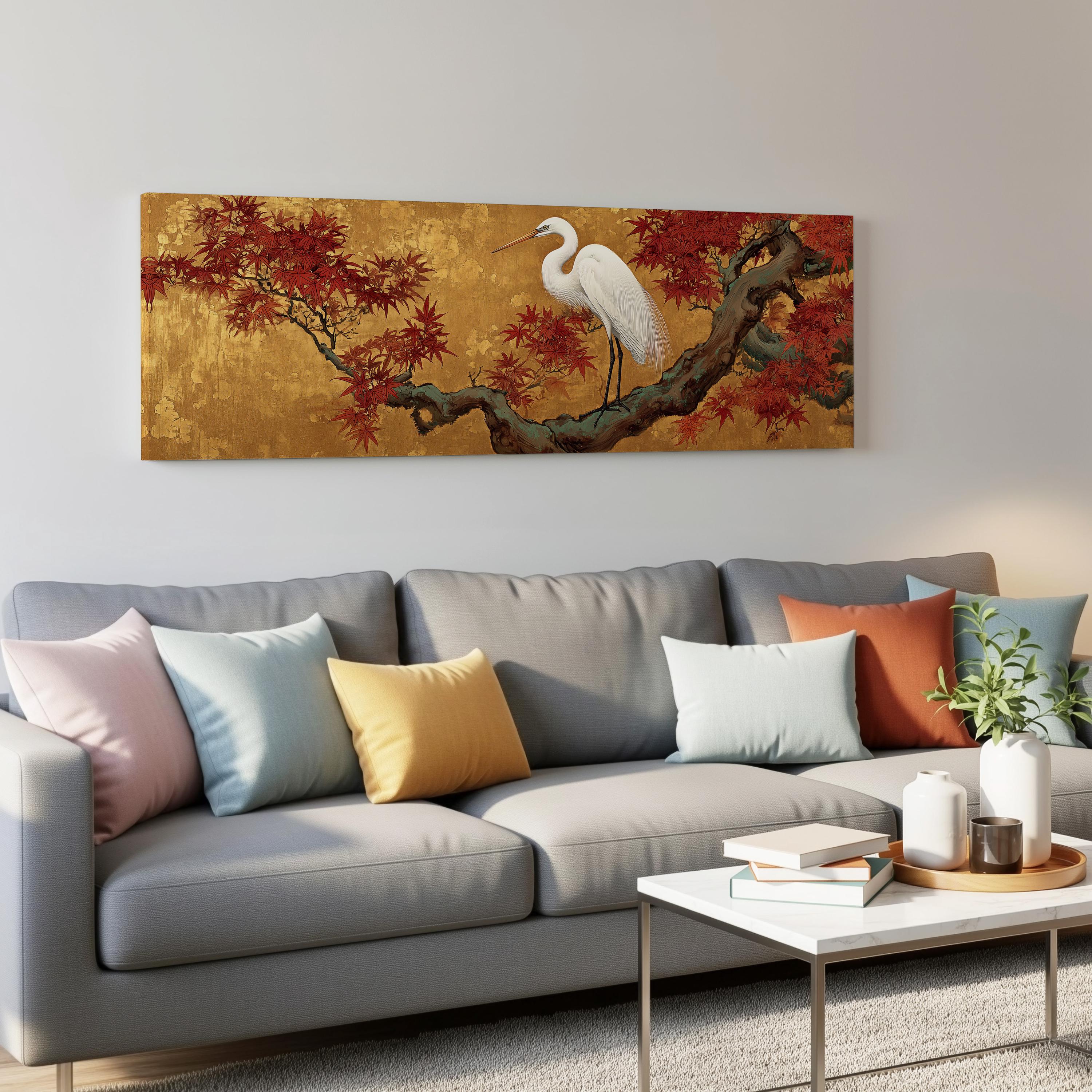 a large painting of a white heron perched on a branch with red leaves, hanging on a wall above a gray couch with colorful throw pillows.