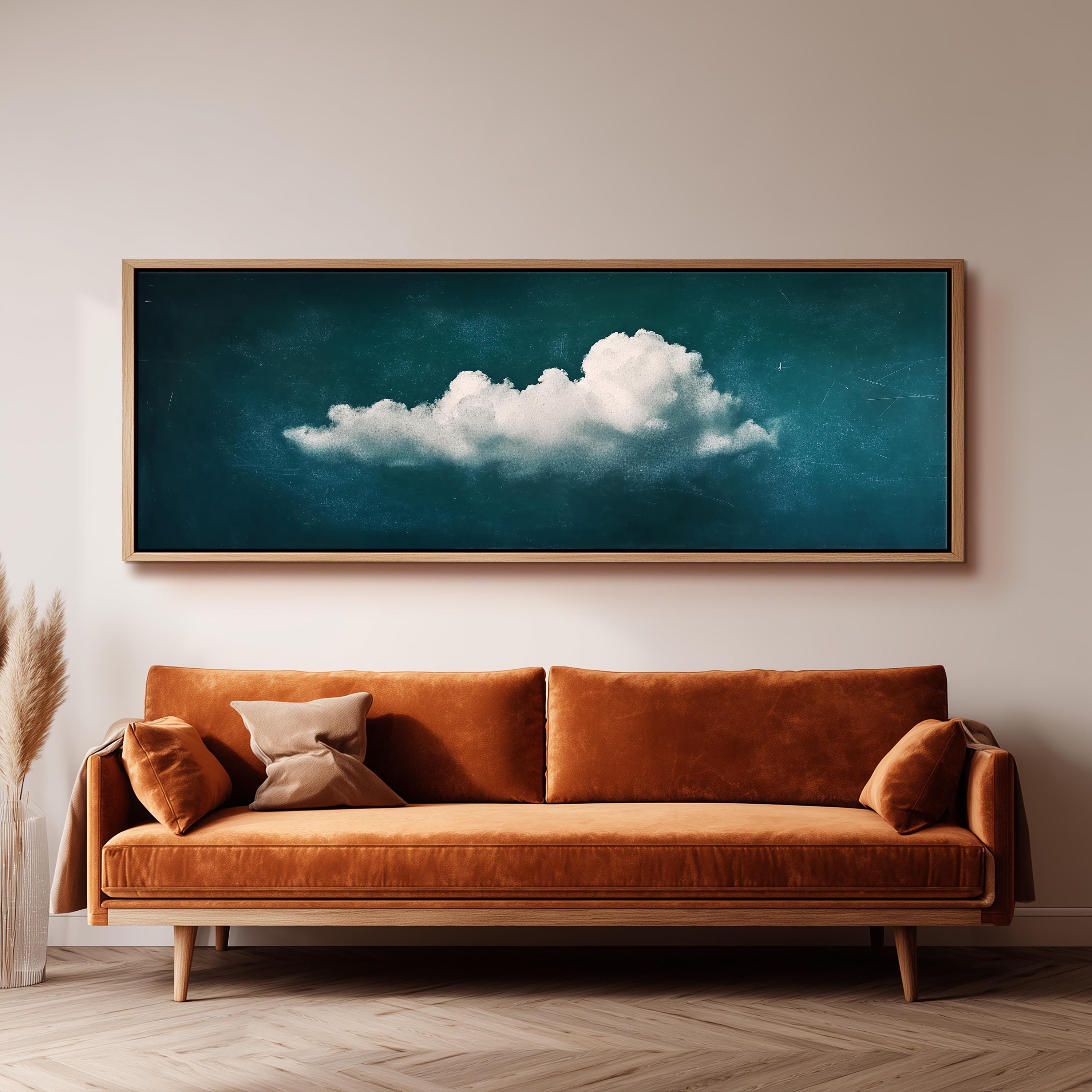 a large, framed painting of a cloud hanging on a wall above a brown sofa.