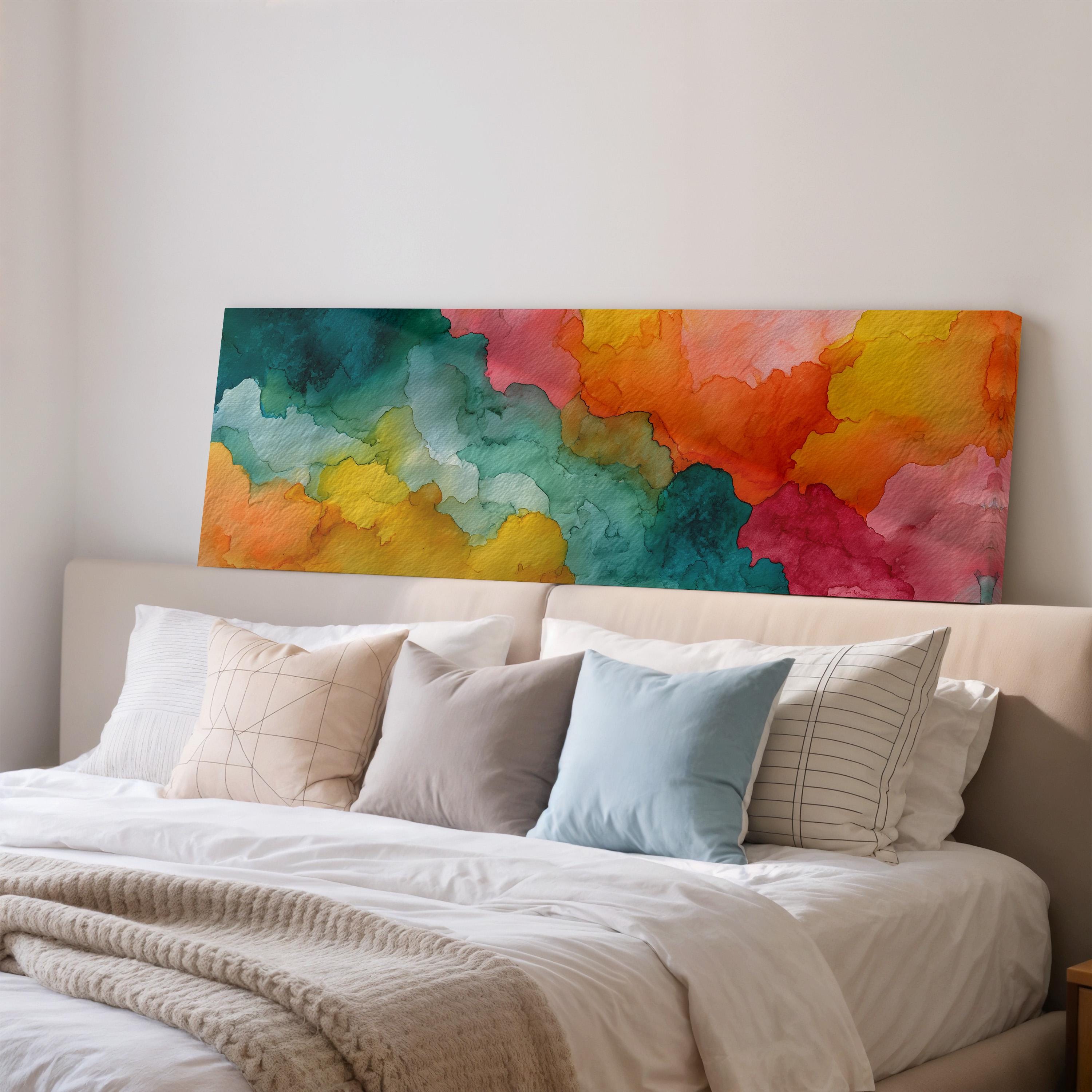 a large, colorful abstract painting hanging on a wall above a bed with white bedding and pillows.