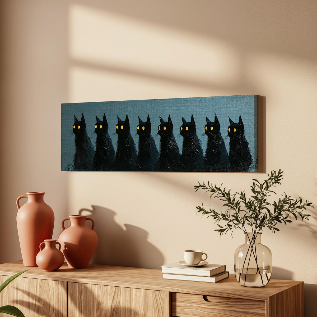 Row of black cats with glowing eyes long horizontal canvas print above a wooden sideboard