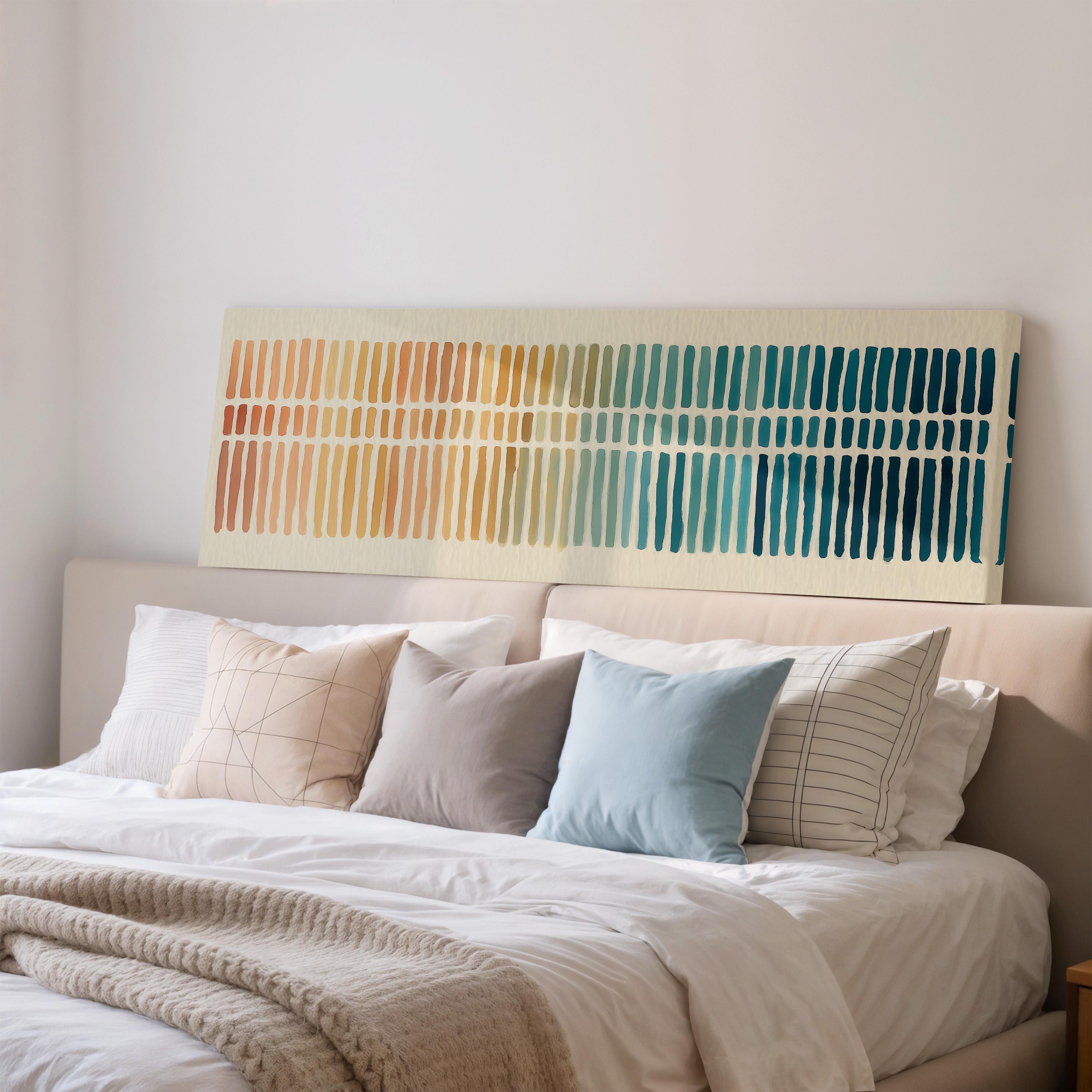 a cozy bedroom with a large bed adorned with a variety of colorful pillows. Above the bed, there is a large abstract painting featuring vertical lines in different colors, creating a vibrant and visually striking display.